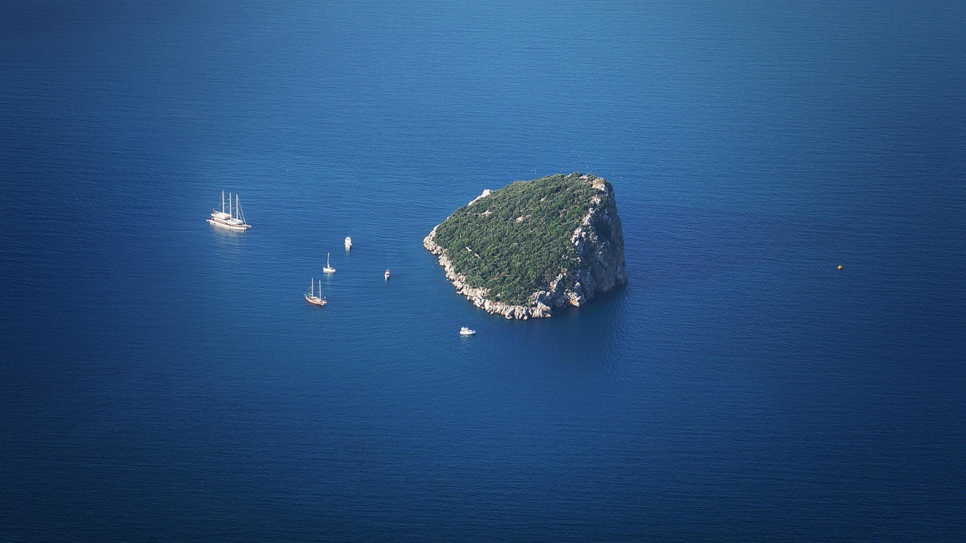 Island with boats in blue sea, aerial view HD Wallpaper