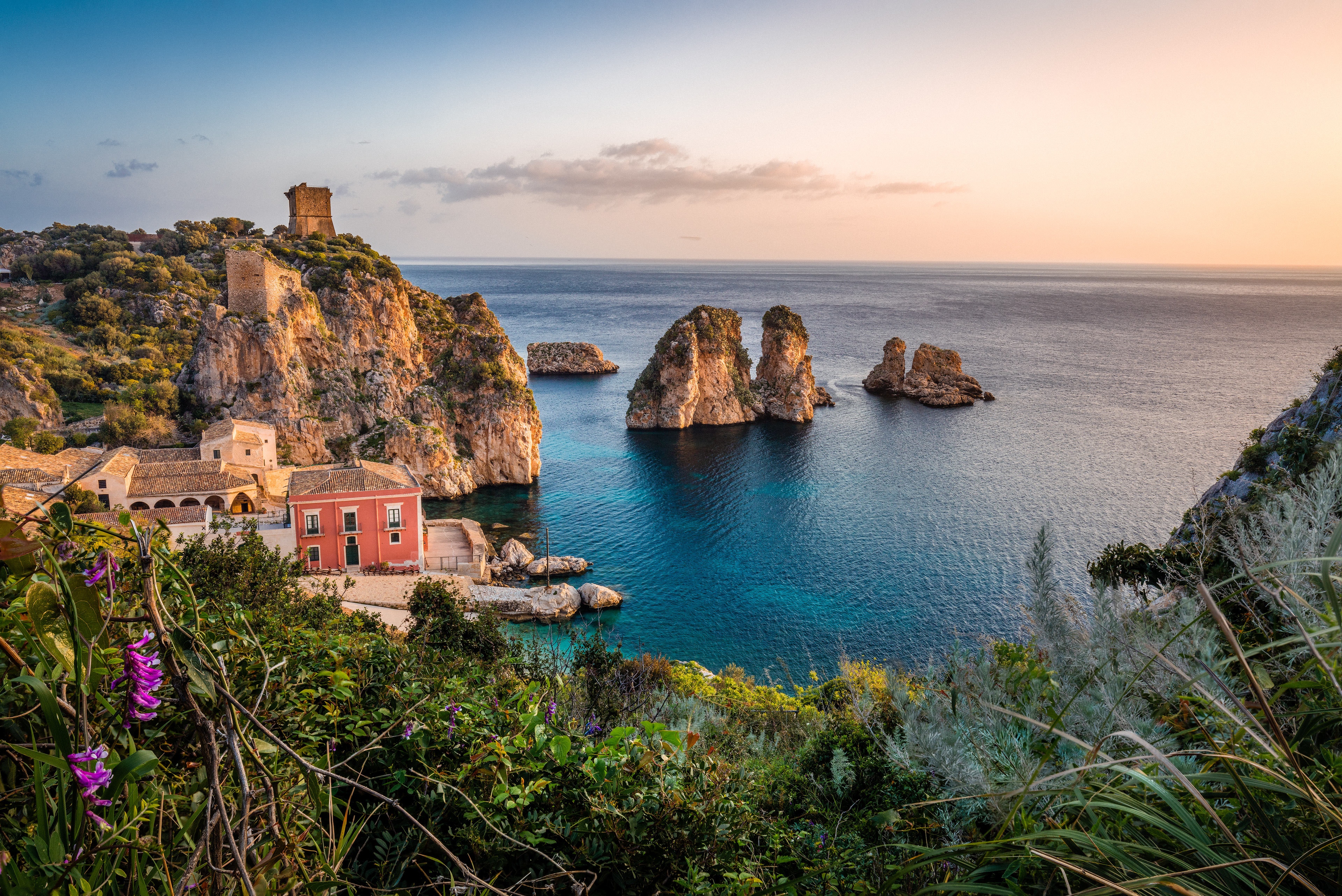 Coastal village with ancient tower and sea stacks at sunset HD Wallpaper
