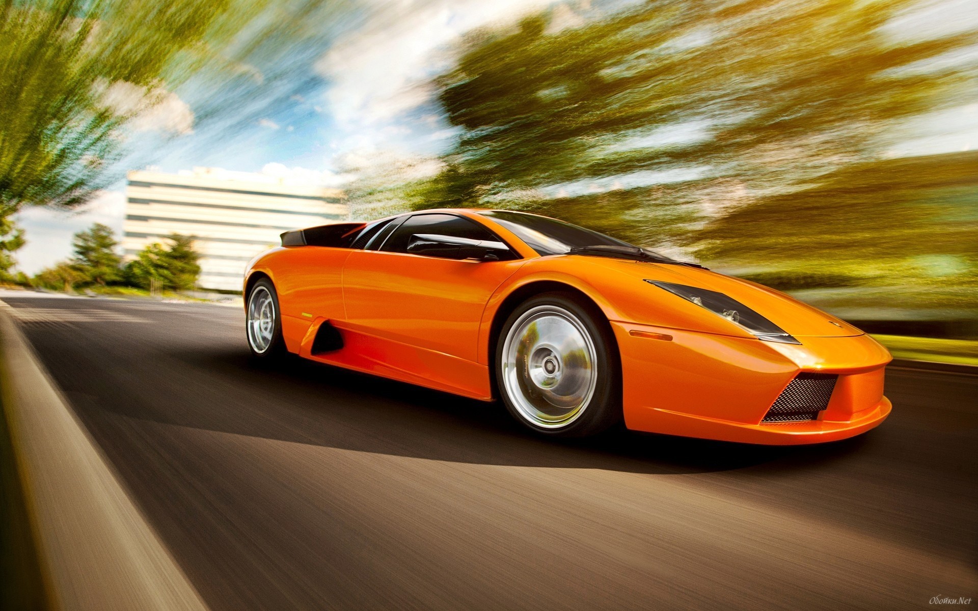 Orange Lamborghini Murcielago driving on a road HD Wallpaper