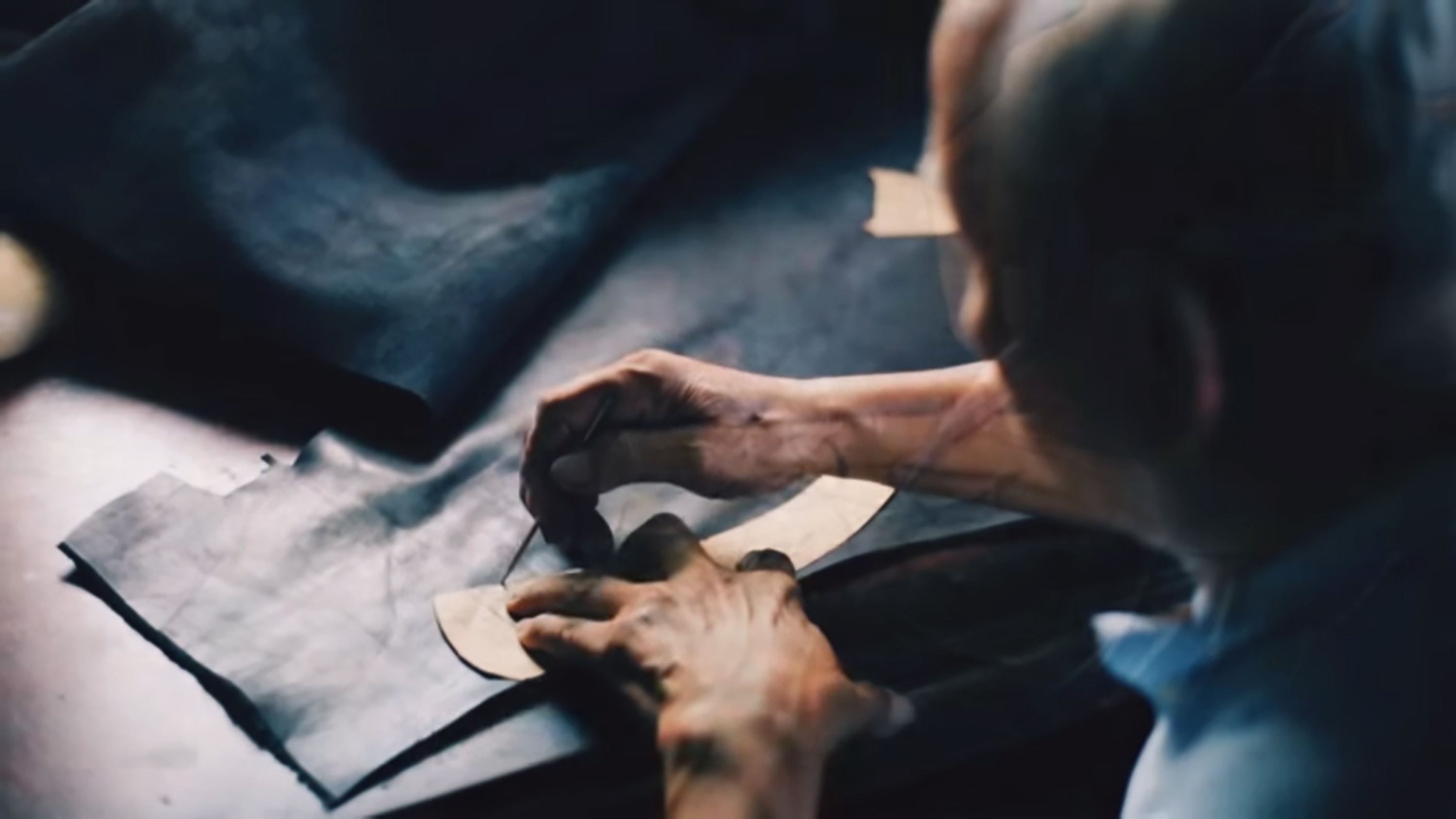 Old man drawing outline on leather with a template HD Wallpaper