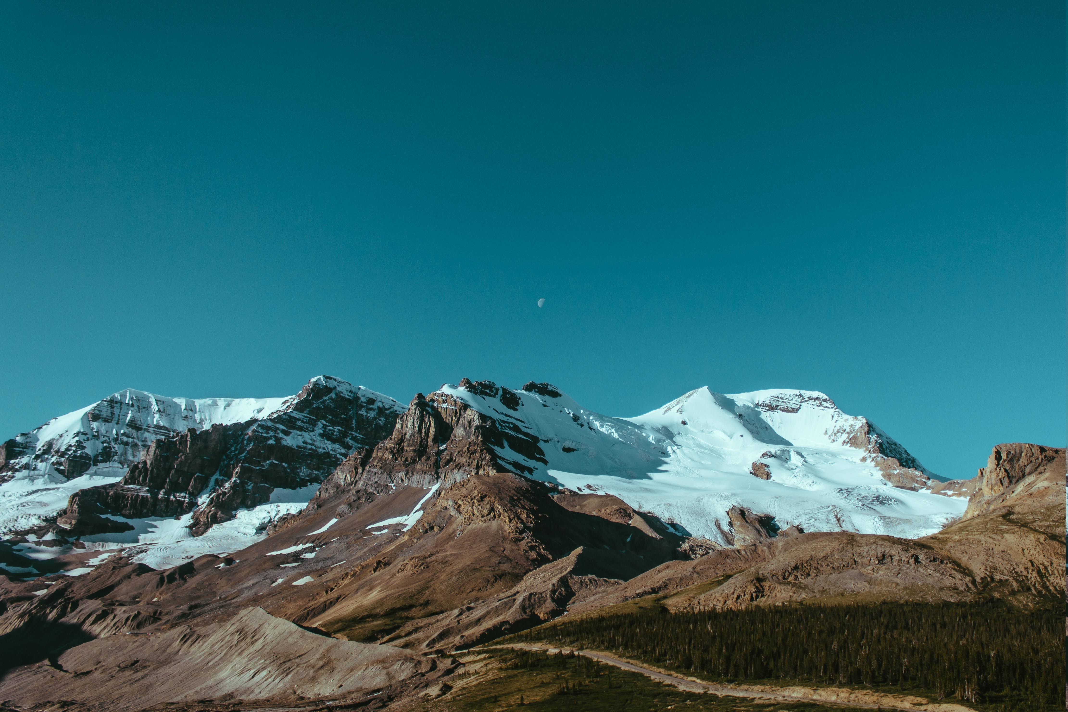Snow-capped mountains under a clear blue sky HD Wallpaper