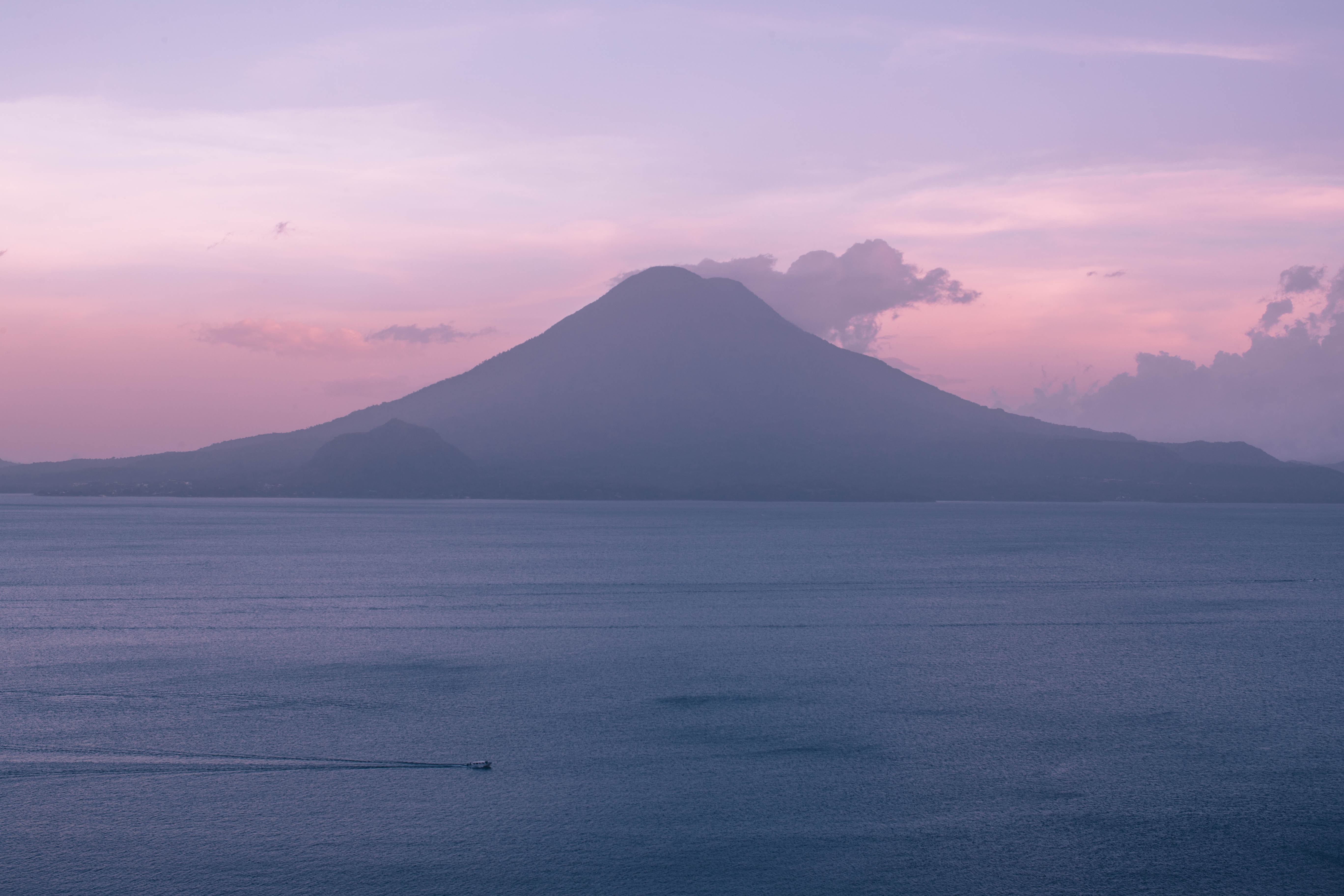 Mountain and lake at sunset with a boat HD Wallpaper