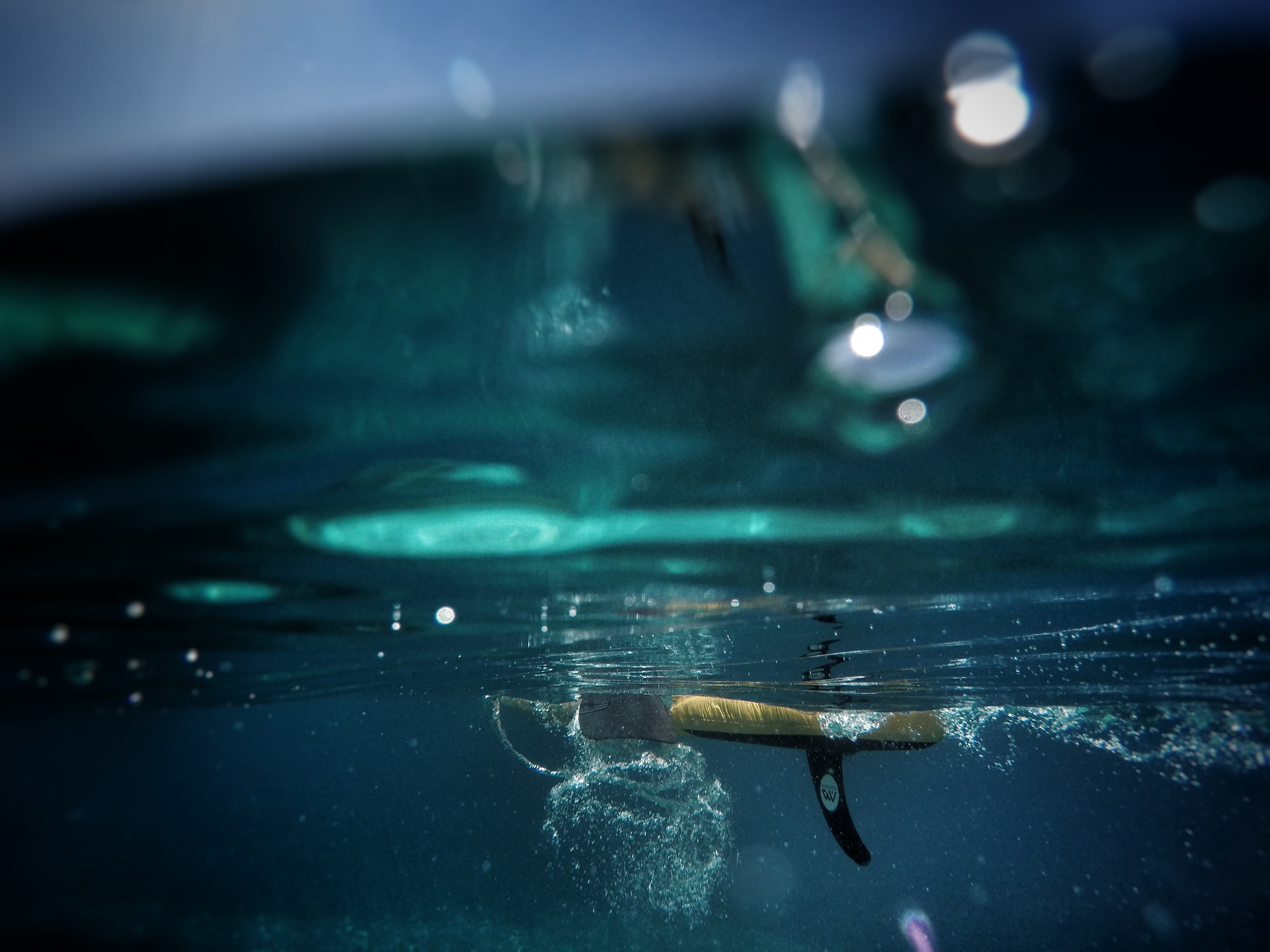 Underwater view of a surfer on a surfboard with a fin HD Wallpaper