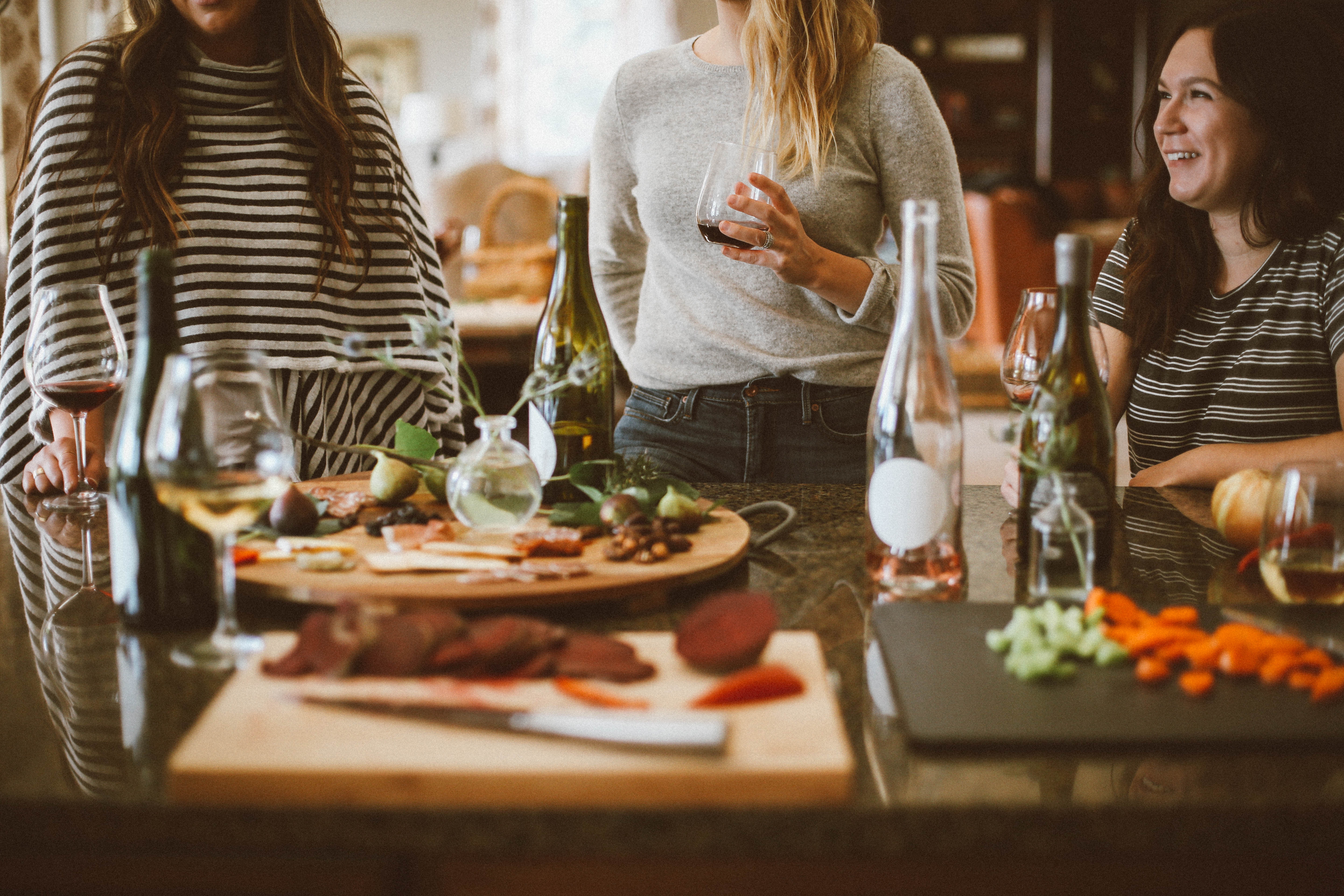Women enjoying a dinner party with wine and charcuterie HD Wallpaper