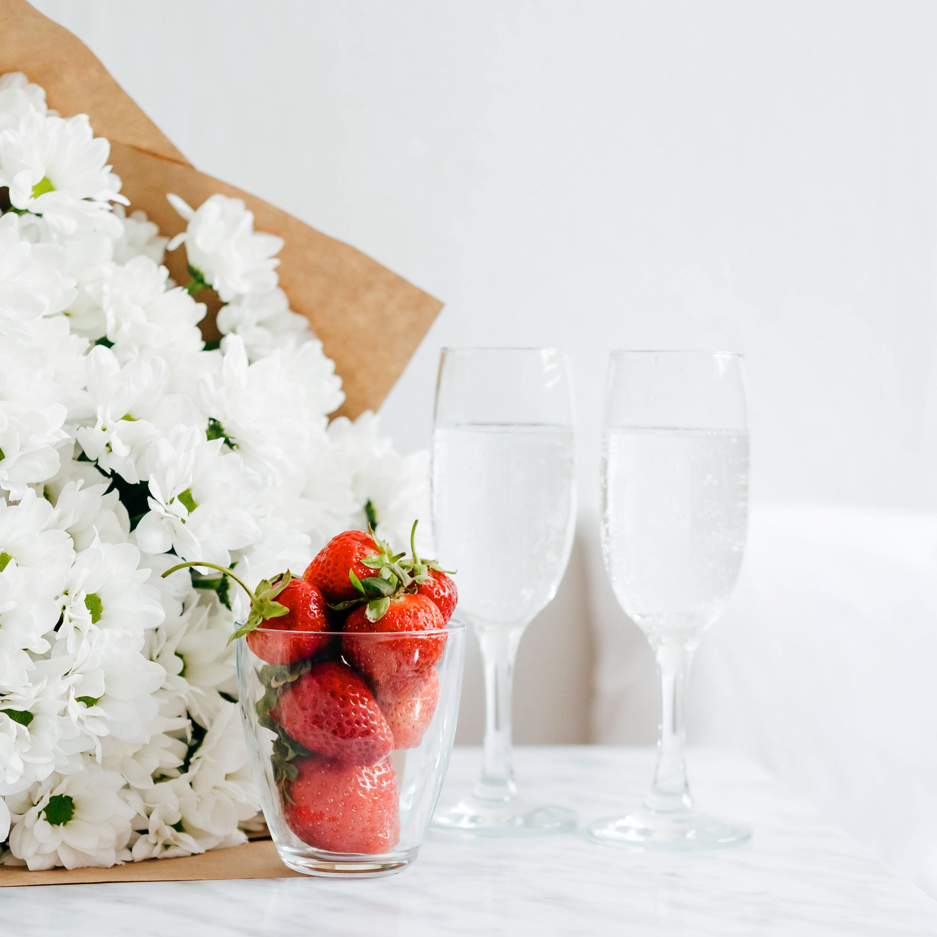 Strawberries and white flowers with champagne glasses HD Wallpaper