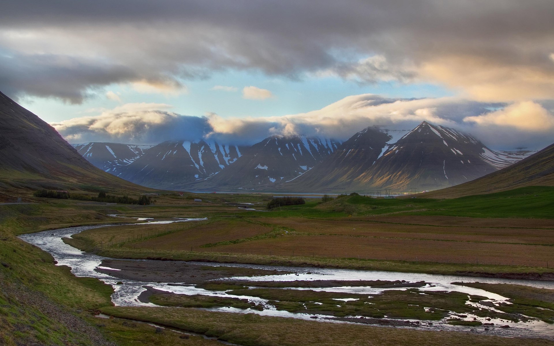 River flowing through a valley with snow-capped mountains HD Wallpaper