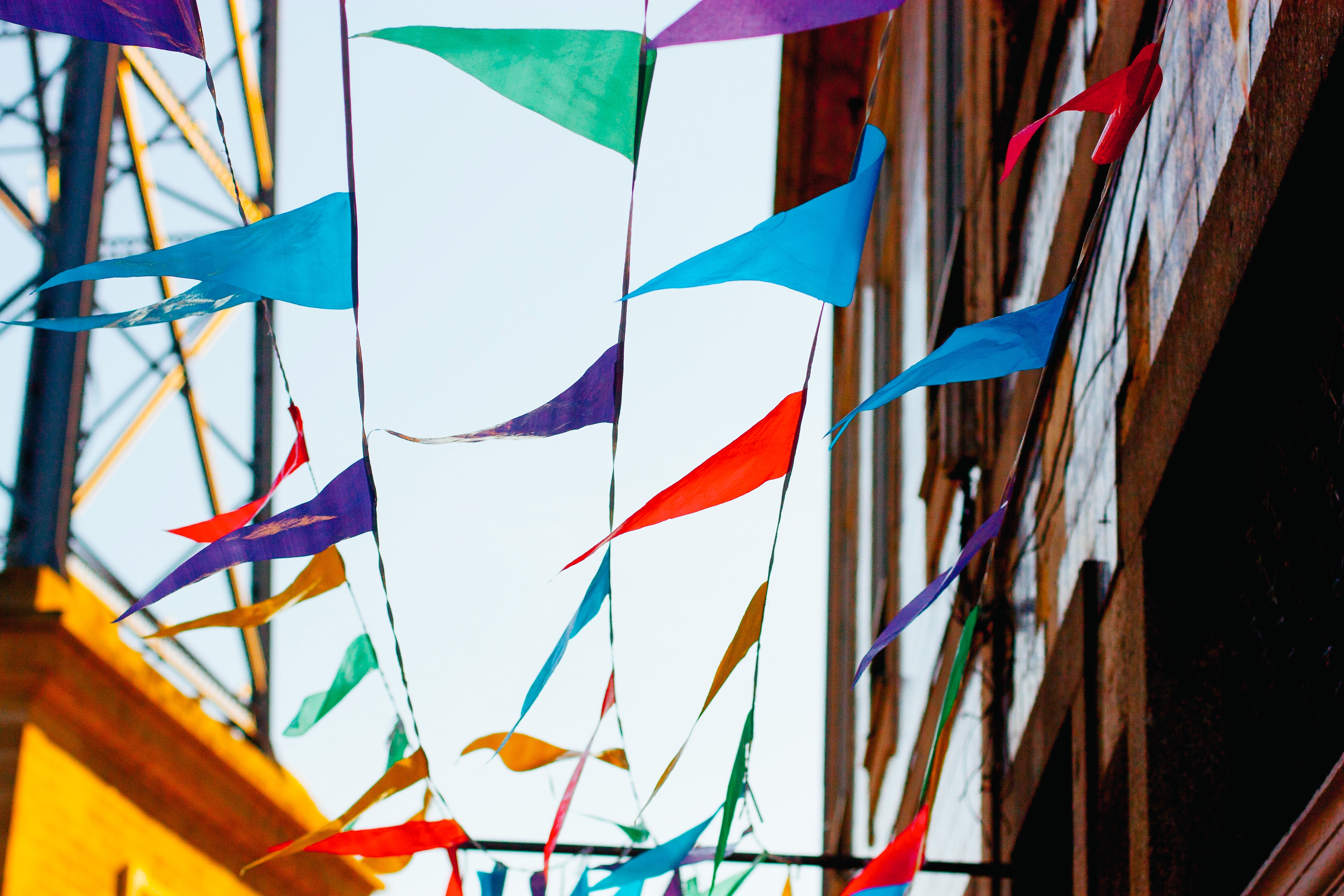 Colorful bunting flags strung across a street HD Wallpaper