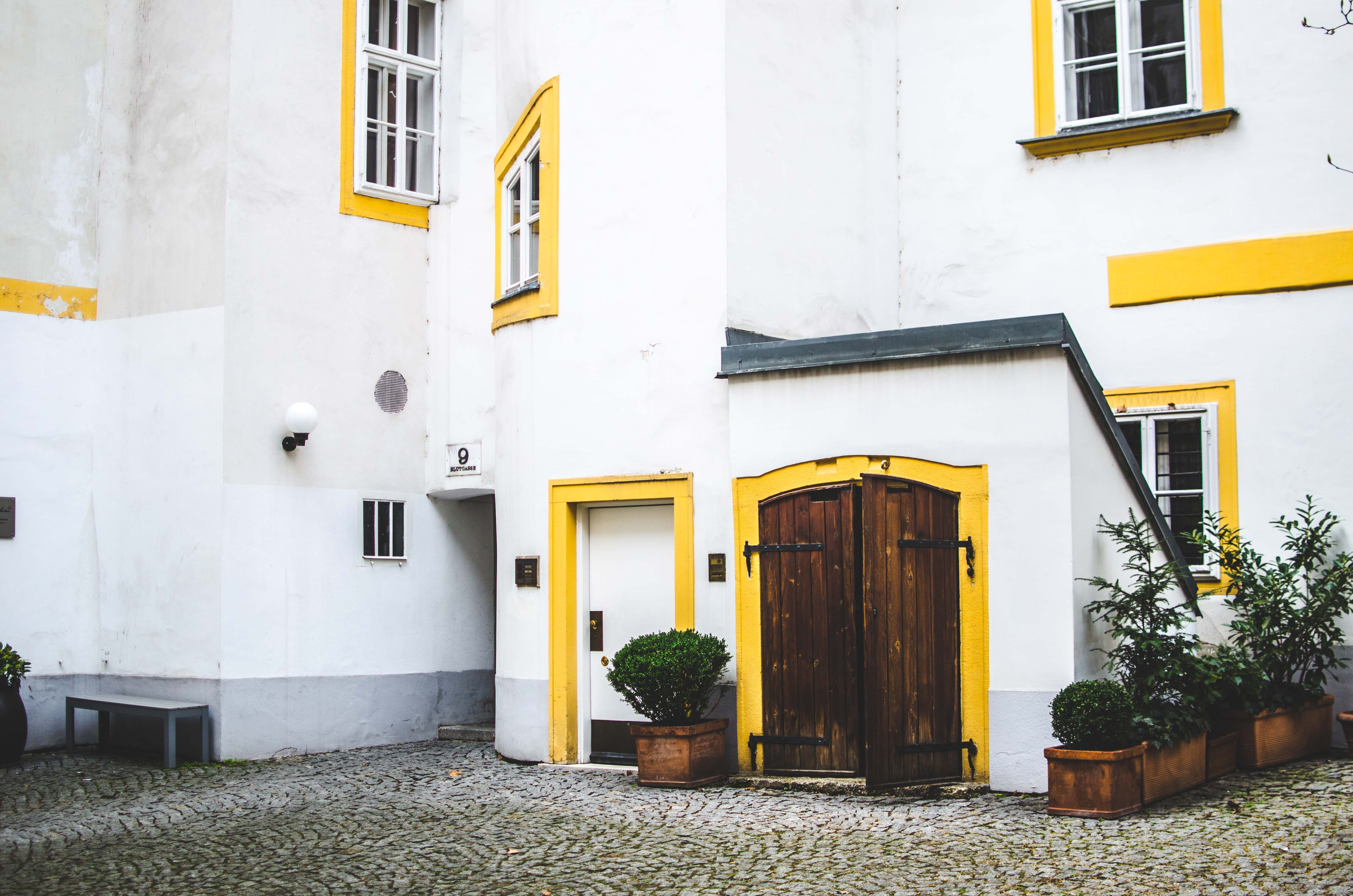 White building with yellow accents and wooden doors HD Wallpaper