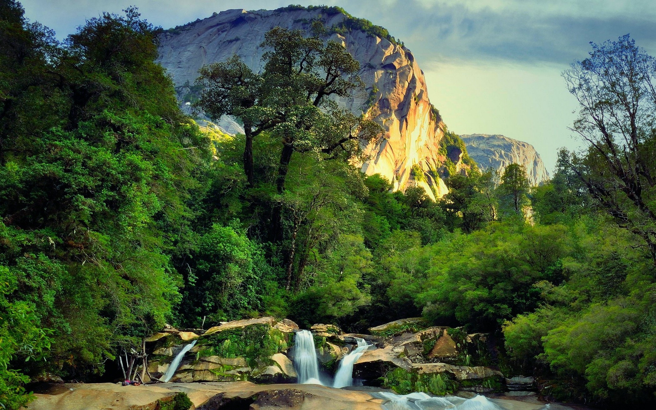 Waterfall in a forest with a mountain at sunset HD Wallpaper