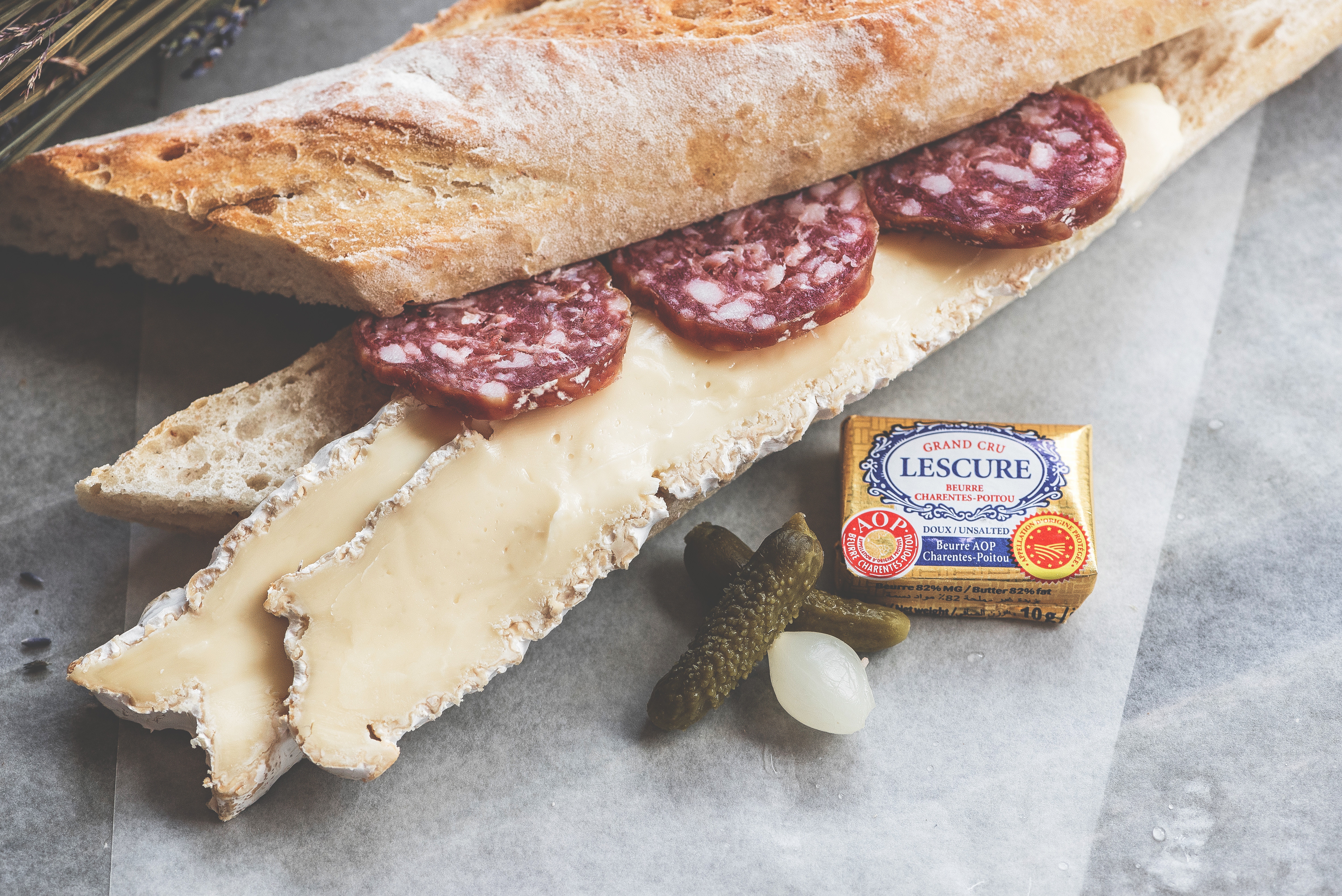 Baguette sandwich with salami, brie, and butter HD Wallpaper