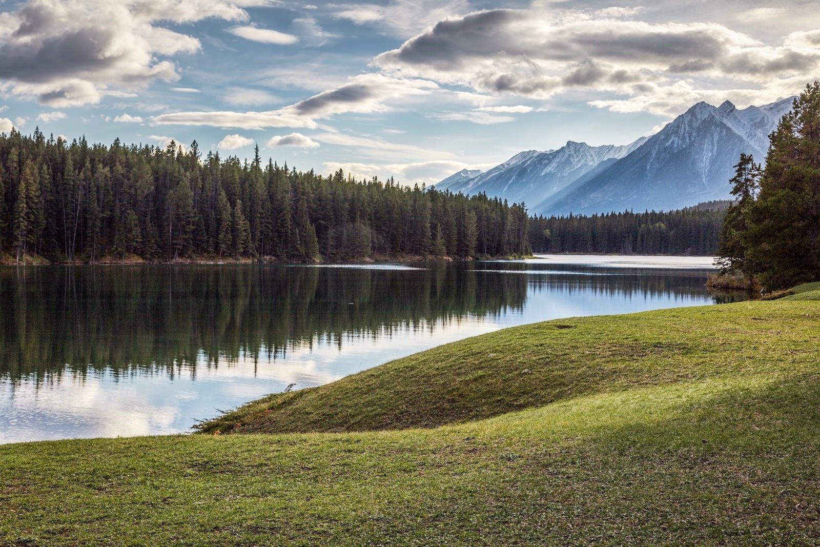 Serene Lake Surrounded by Forest and Mountains HD Wallpaper