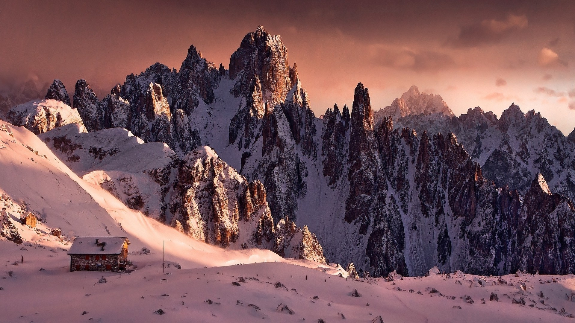 Snowy mountain range at sunrise with a cabin HD Wallpaper