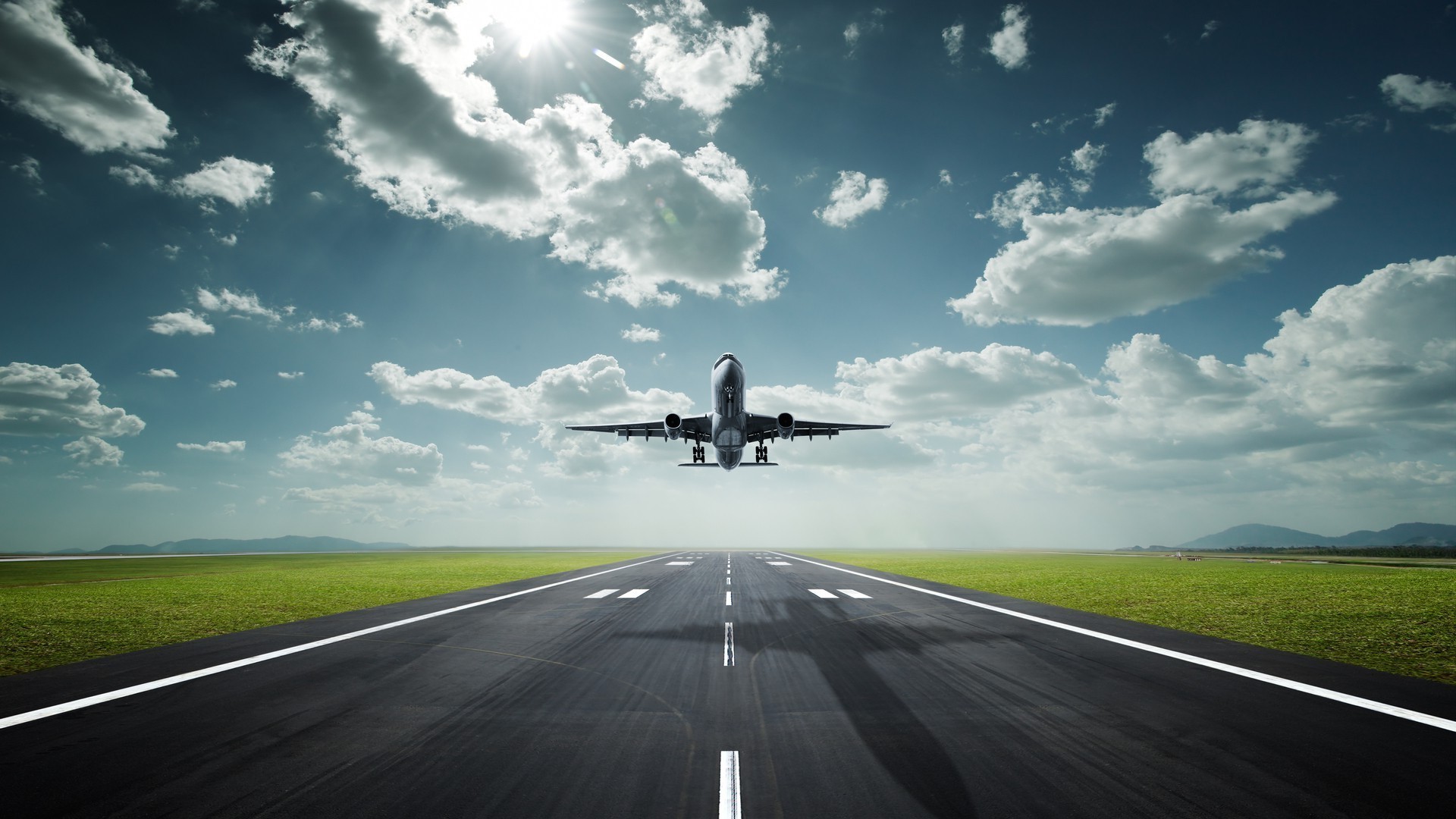 Airplane taking off from runway with clouds and sun HD Wallpaper