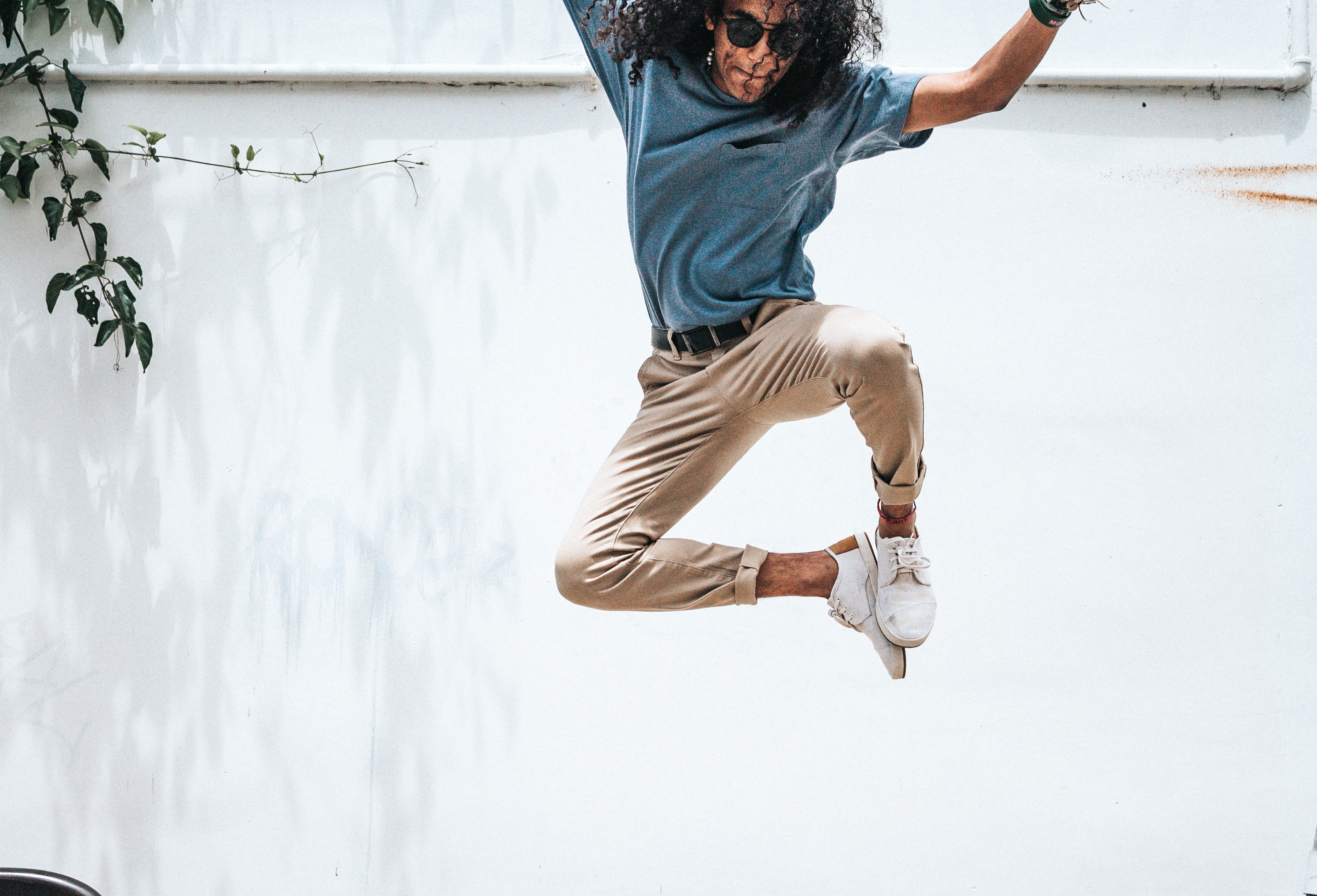 Man jumping in front of a white wall HD Wallpaper