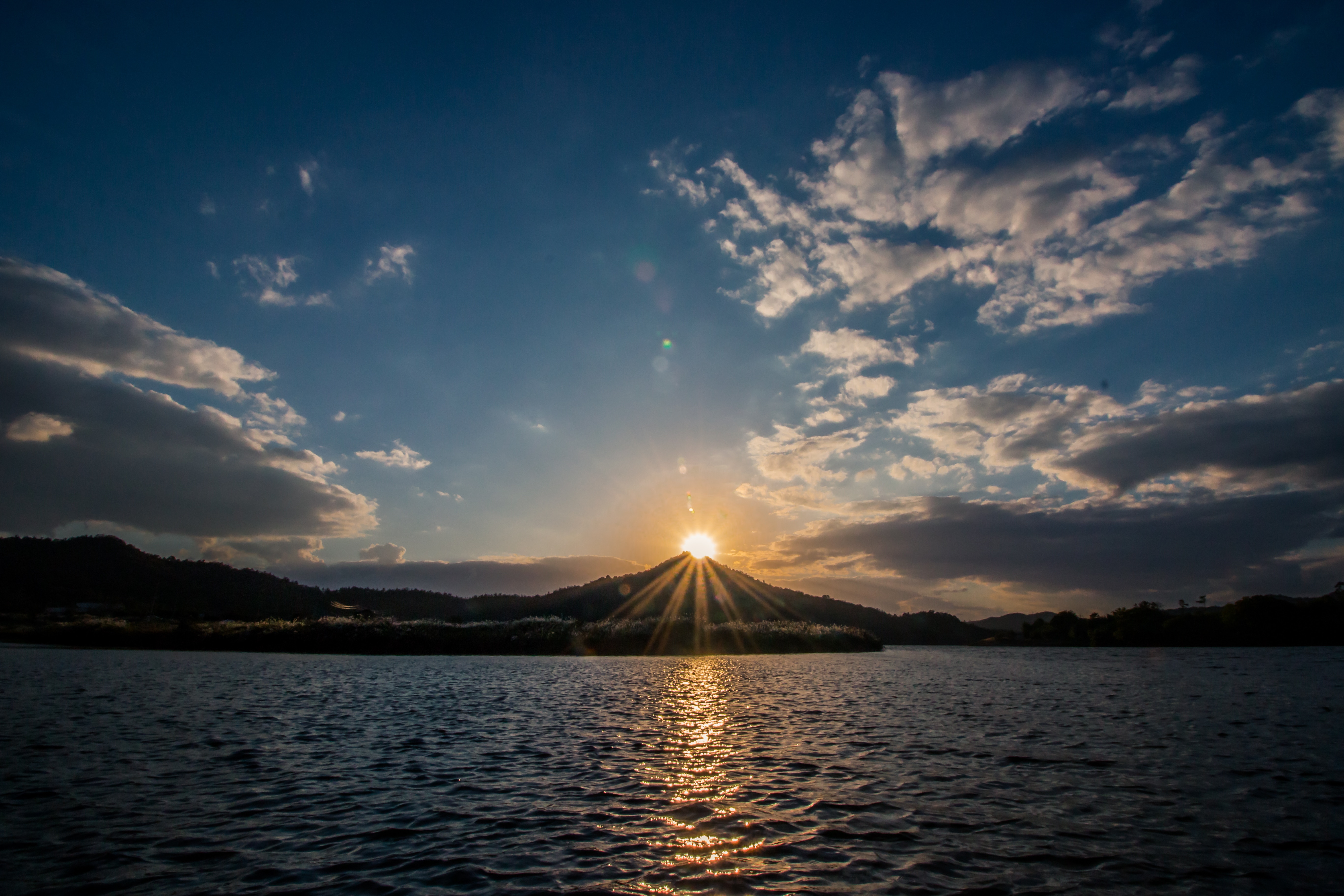 Sunset over a lake with mountains and clouds HD Wallpaper