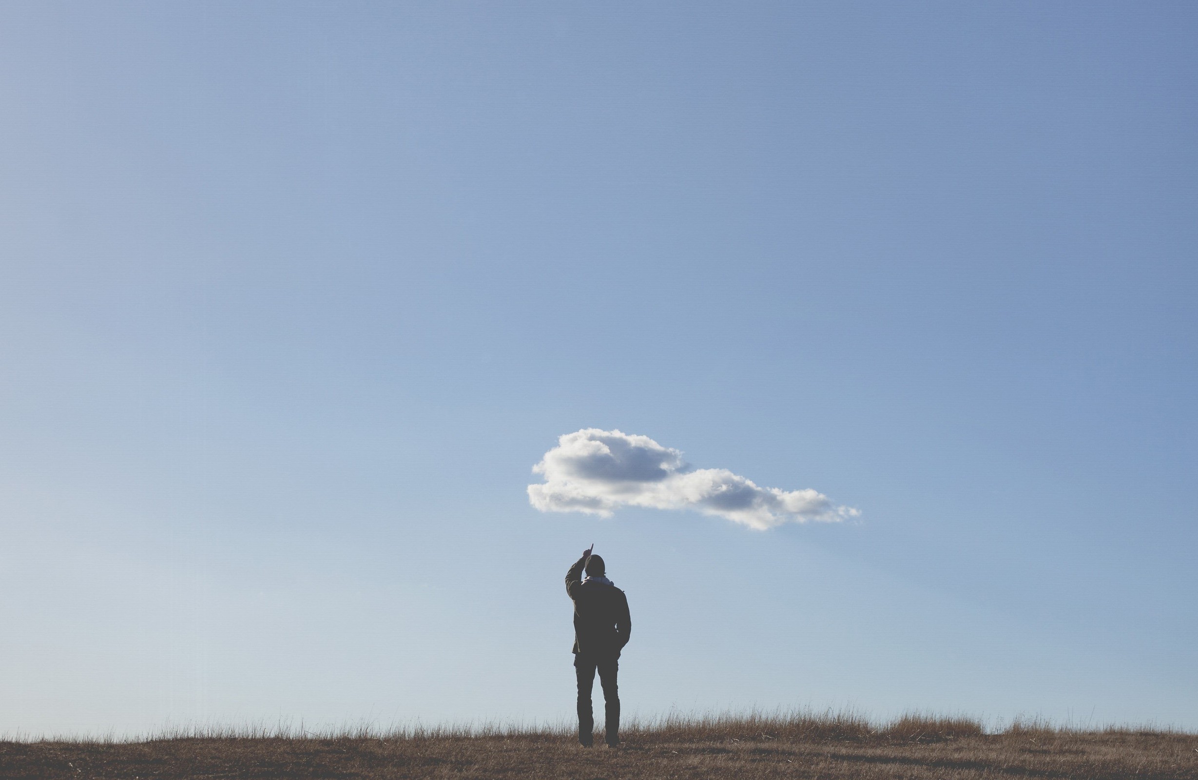 Man pointing at a cloud in a blue sky HD Wallpaper