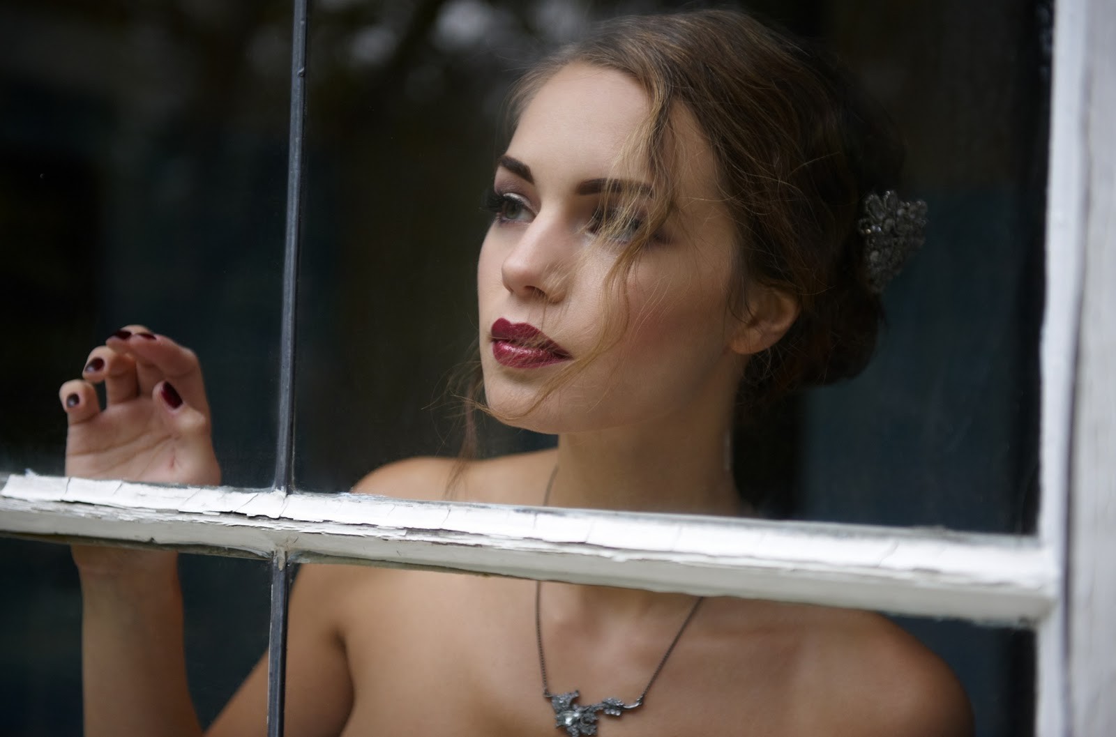 Woman with dark lipstick looking out a window HD Wallpaper