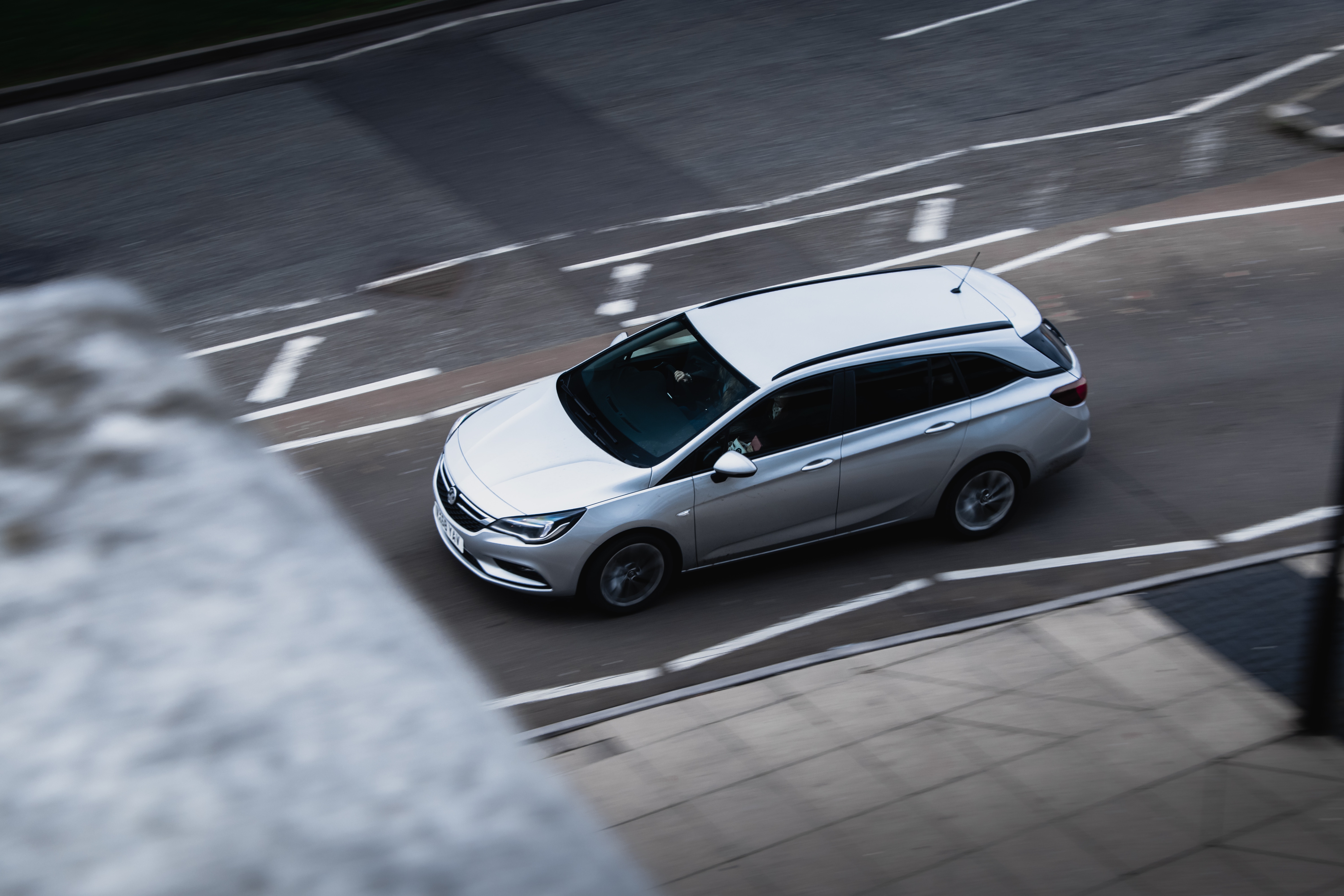 Silver station wagon driving on a city road HD Wallpaper