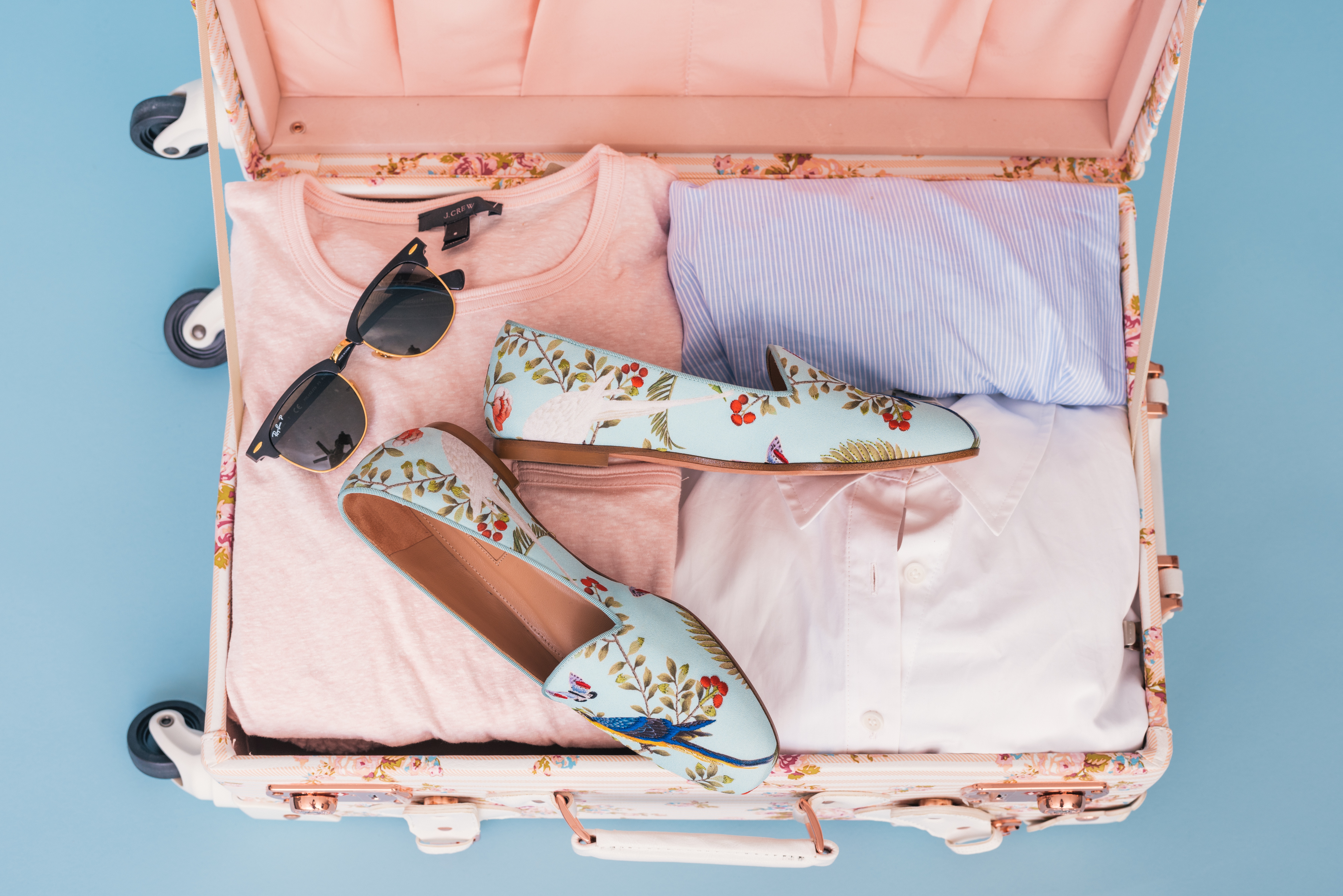 Suitcase packed with clothes, shoes, and sunglasses HD Wallpaper