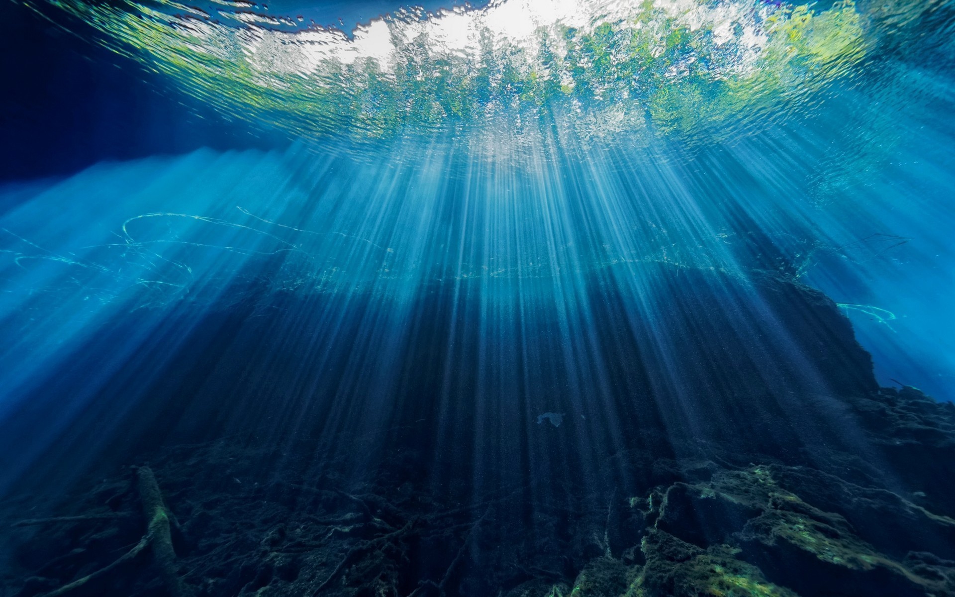 Underwater sun rays piercing the deep blue water HD Wallpaper