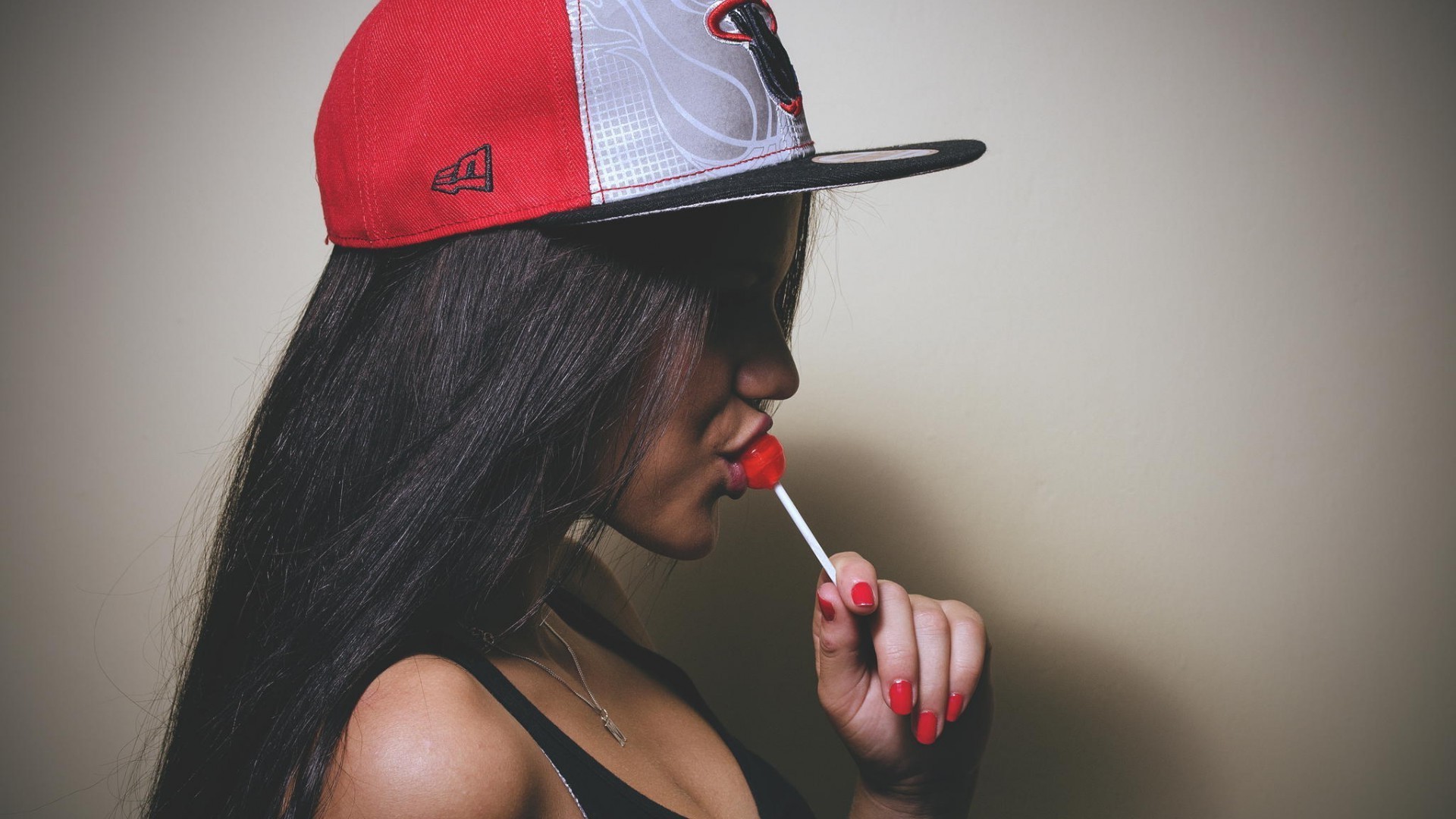 Woman in New Era cap eating a lollipop HD Wallpaper