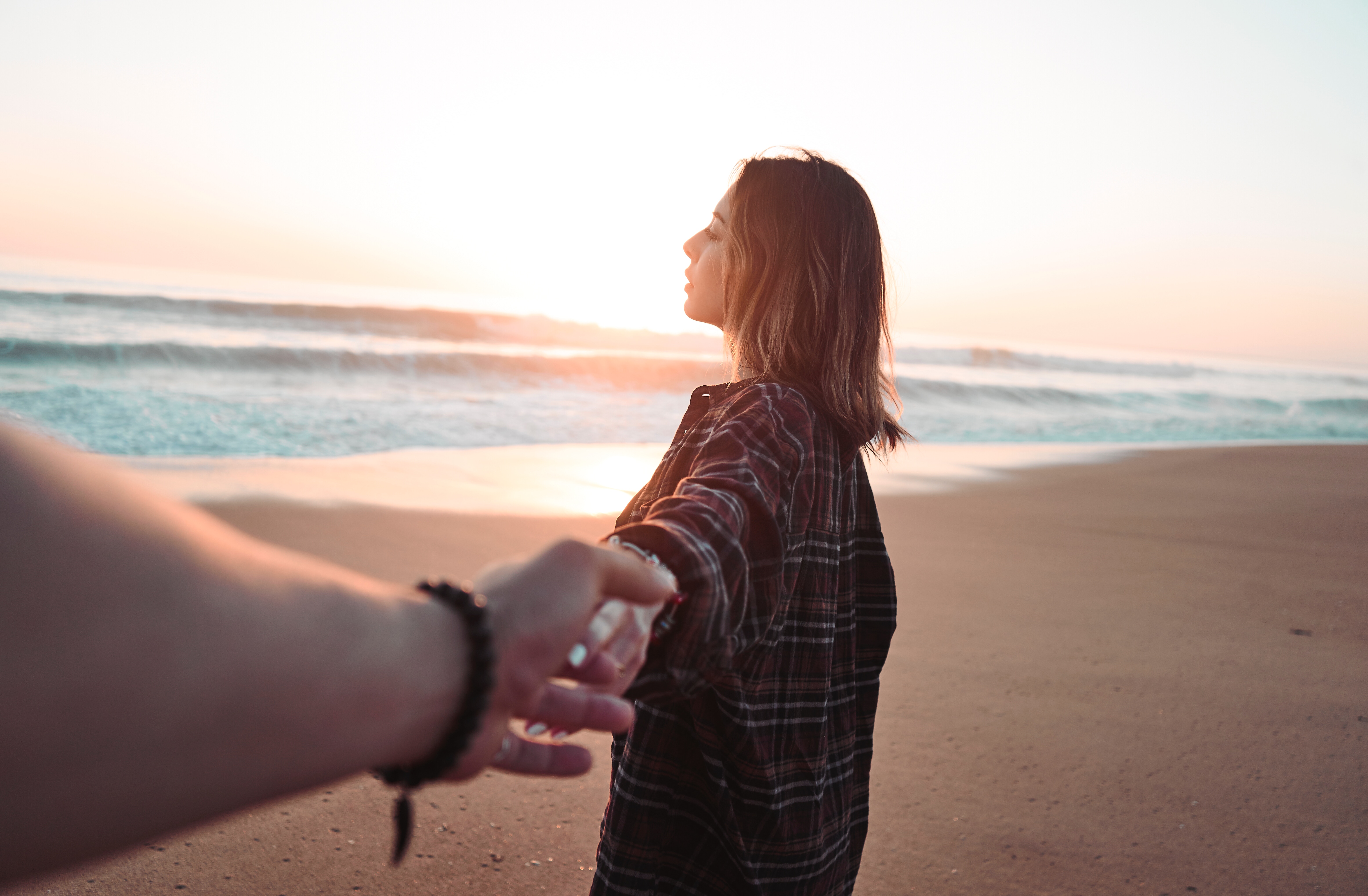 Woman holding hand on beach at sunset HD Wallpaper