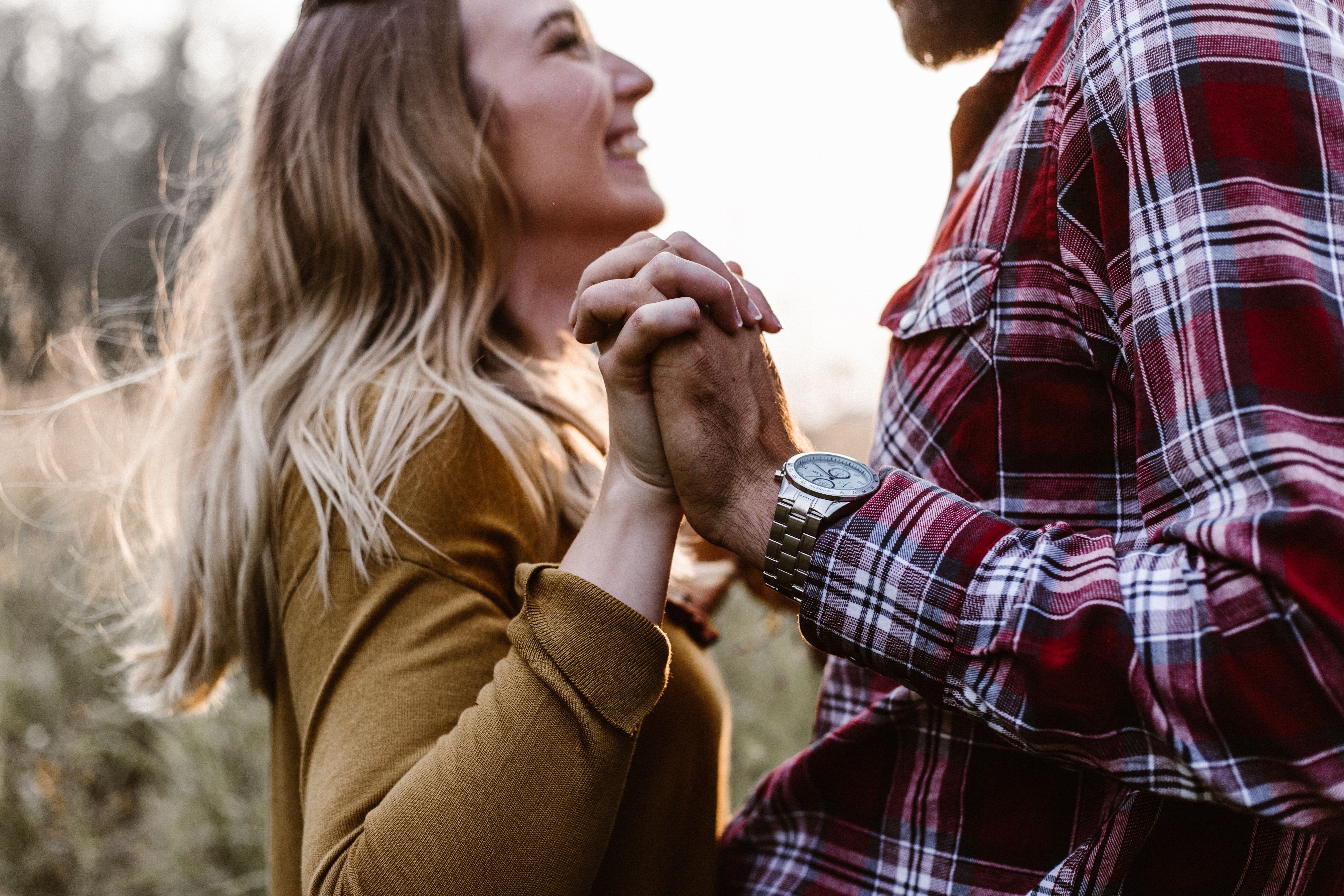 Couple holding hands and laughing outdoors HD Wallpaper