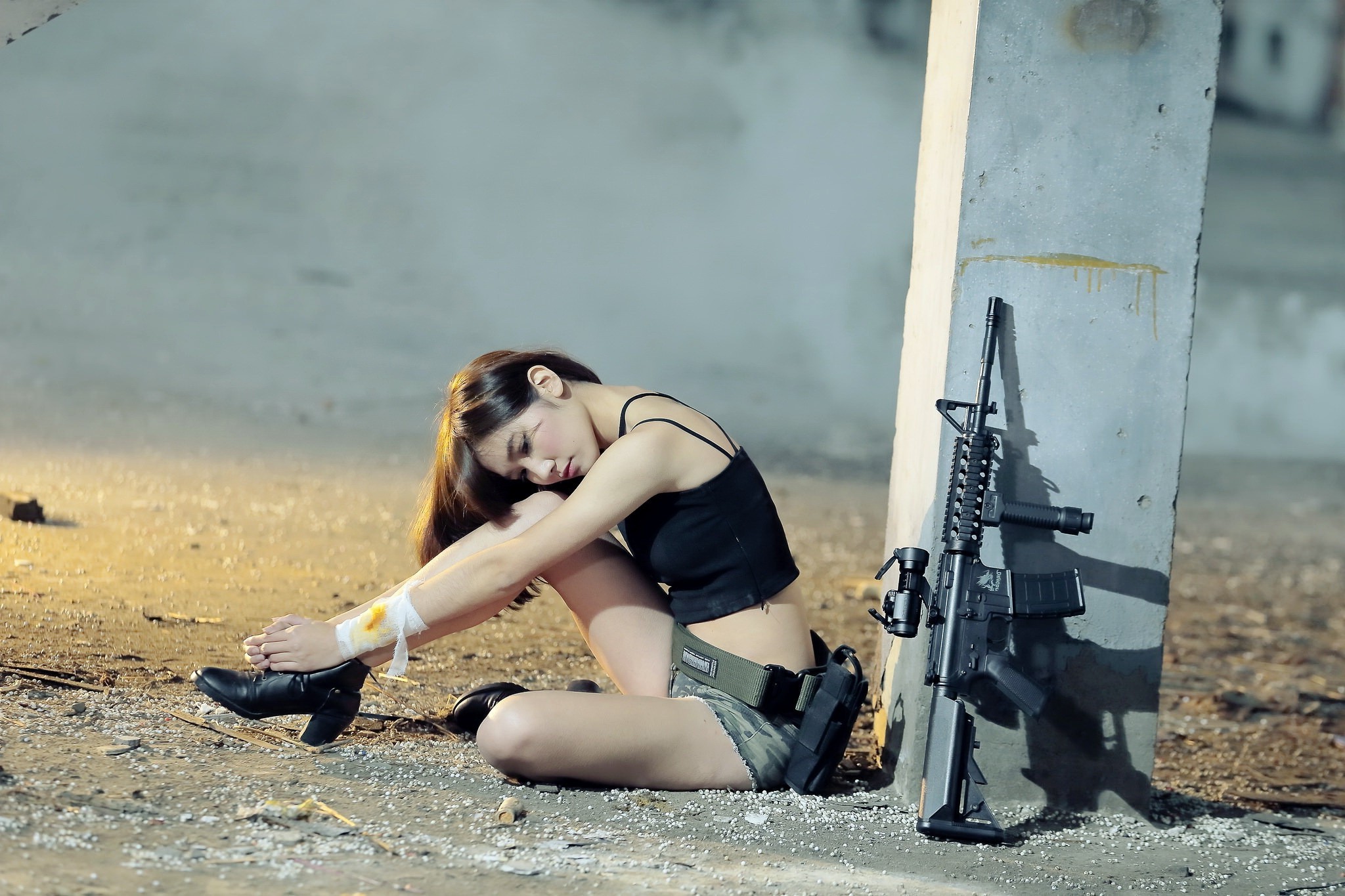 Asian woman with rifle sitting by pillar HD Wallpaper