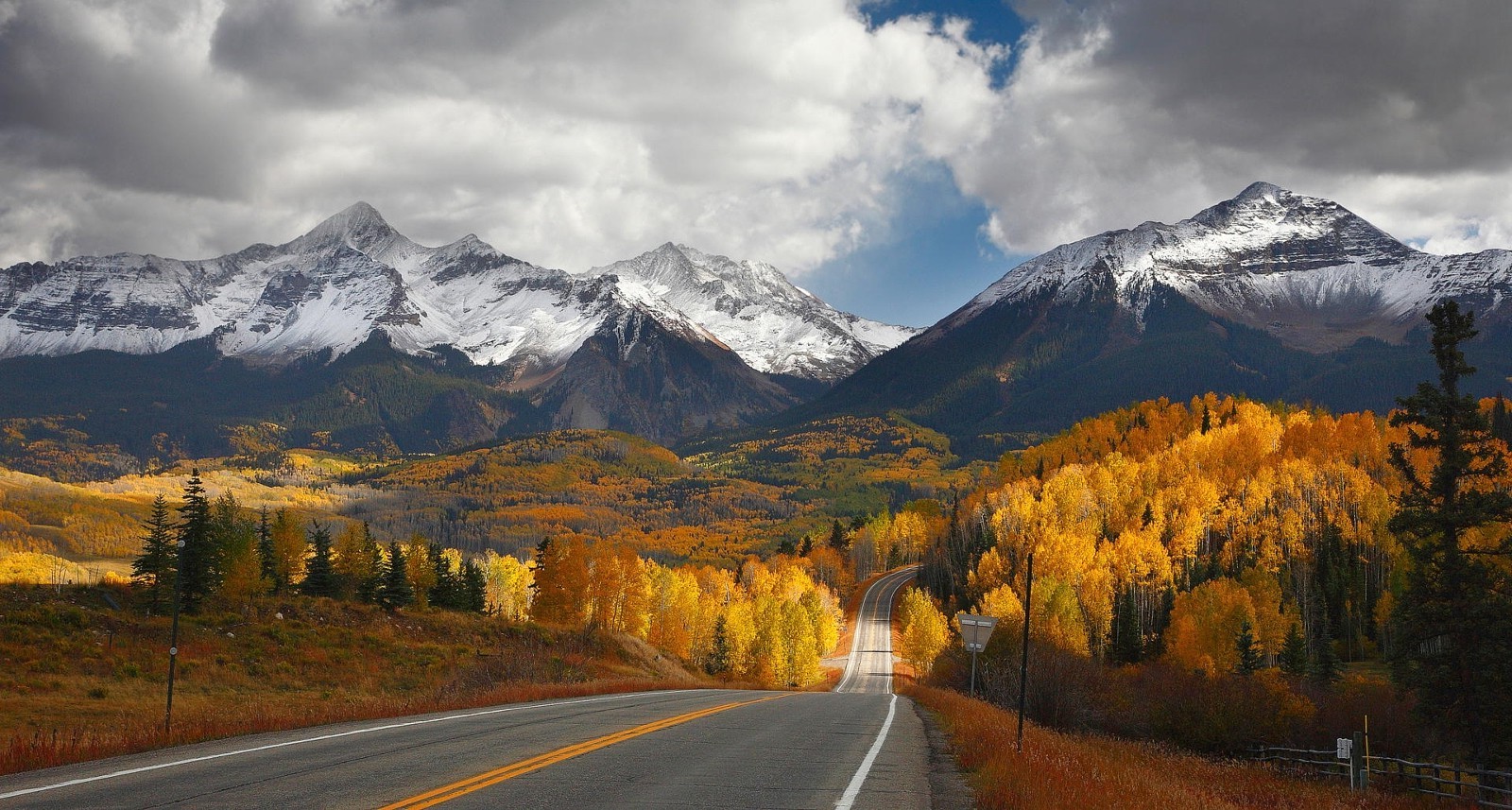 Road leading to snow-capped mountains in fall HD Wallpaper