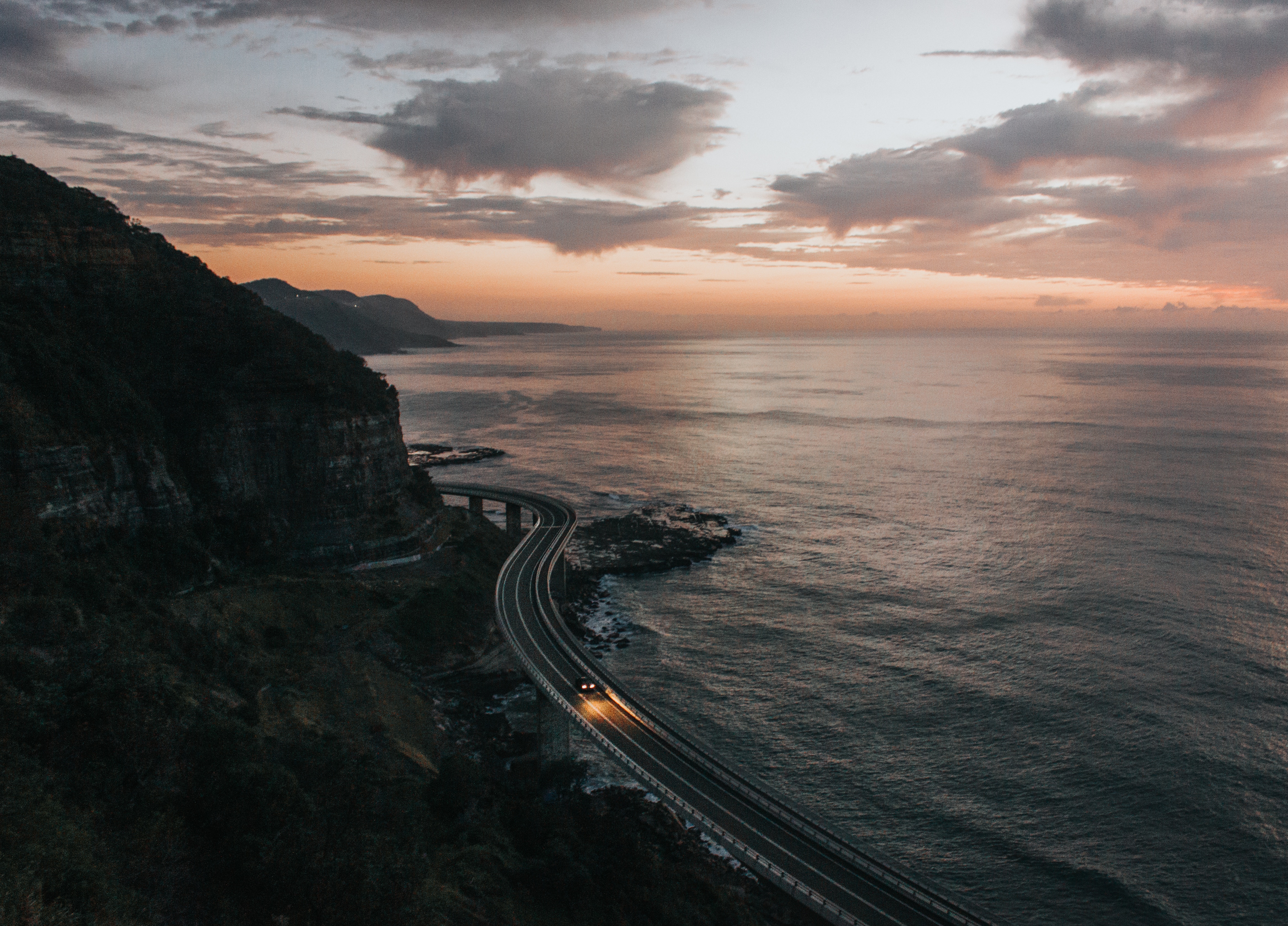 Sea Cliff Bridge at Dusk with Car Headlights HD Wallpaper