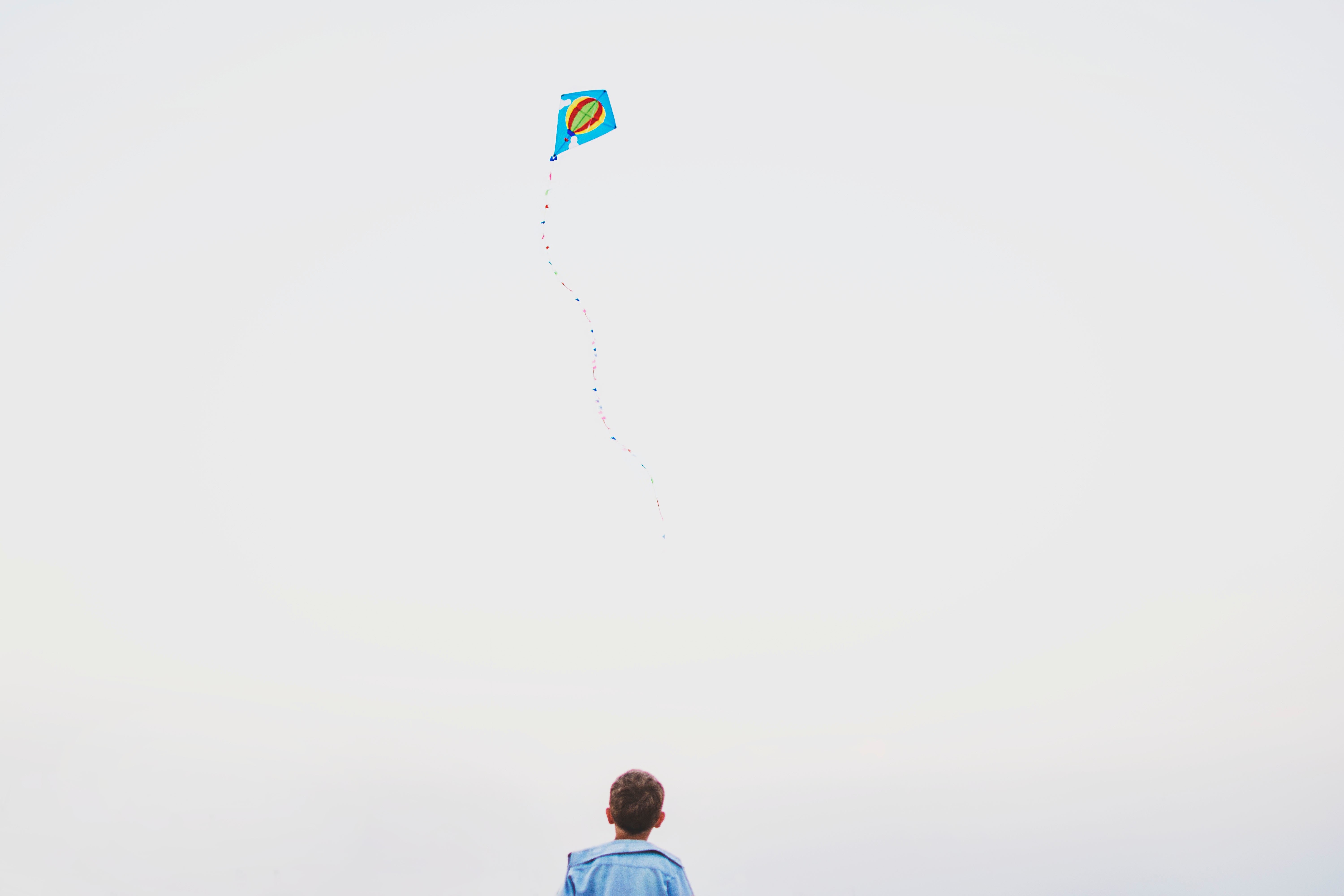 Boy flying a kite in the sky HD Wallpaper