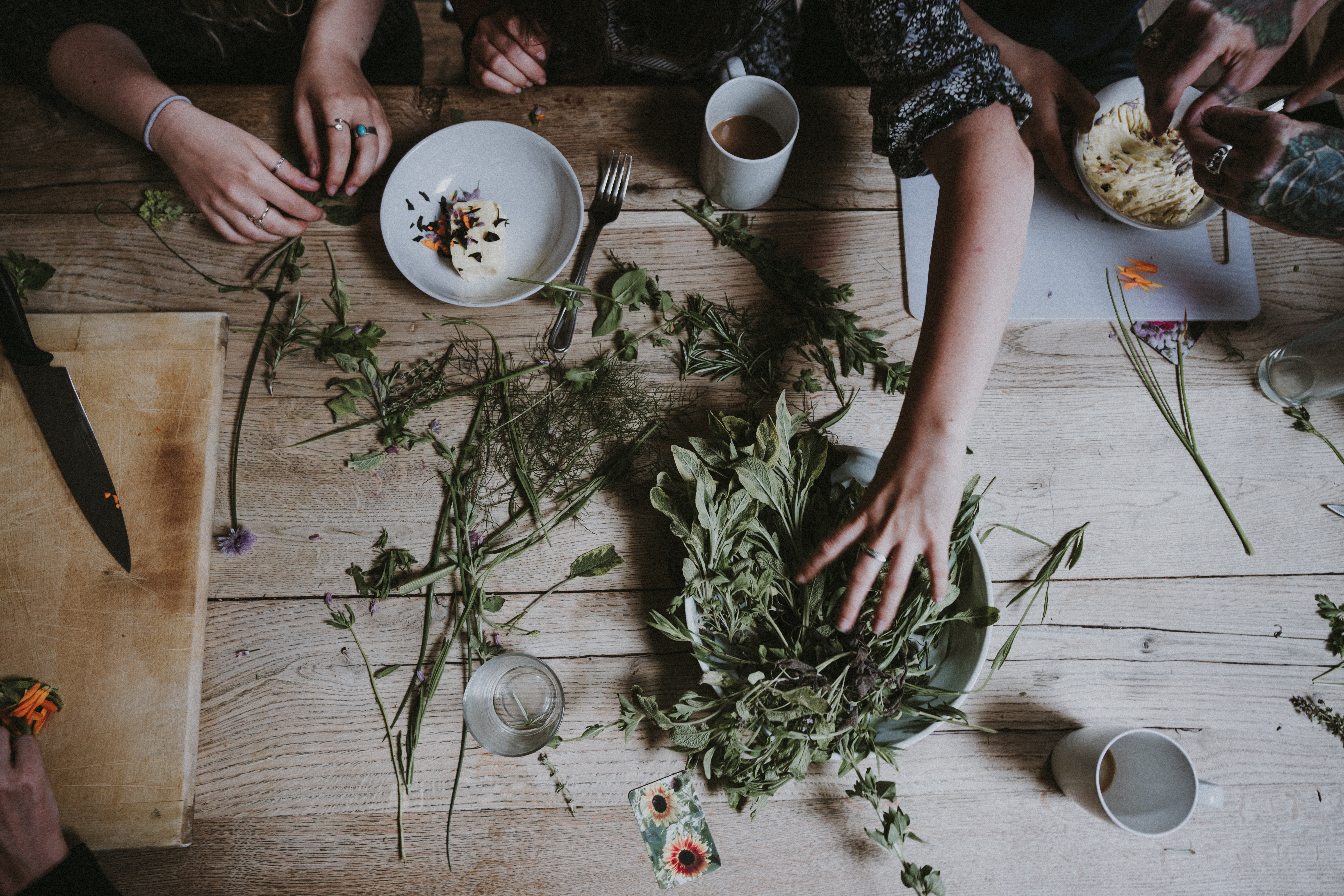 Hands preparing herbs and food on a wooden table HD Wallpaper