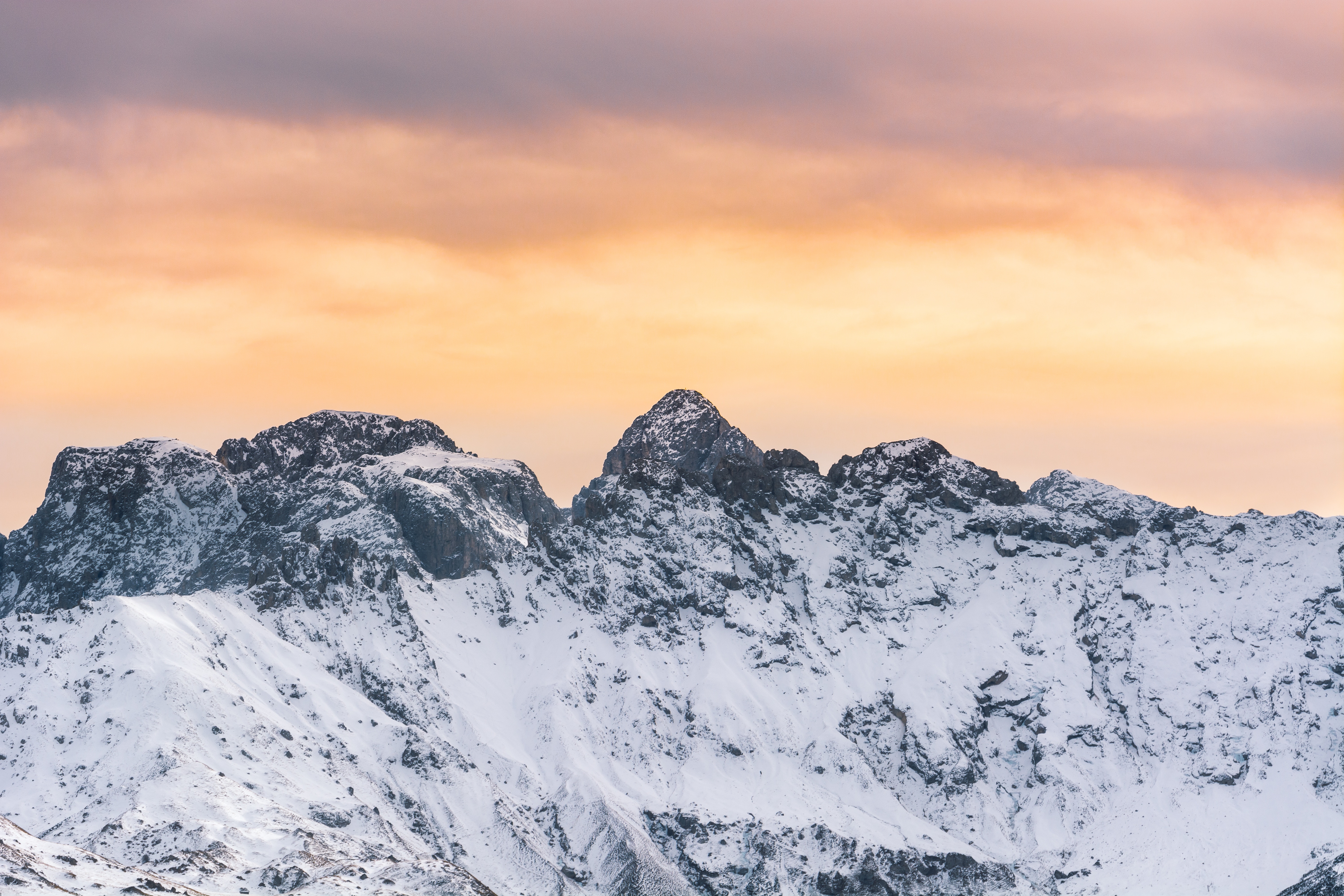 Snow-covered mountain range at sunset HD Wallpaper