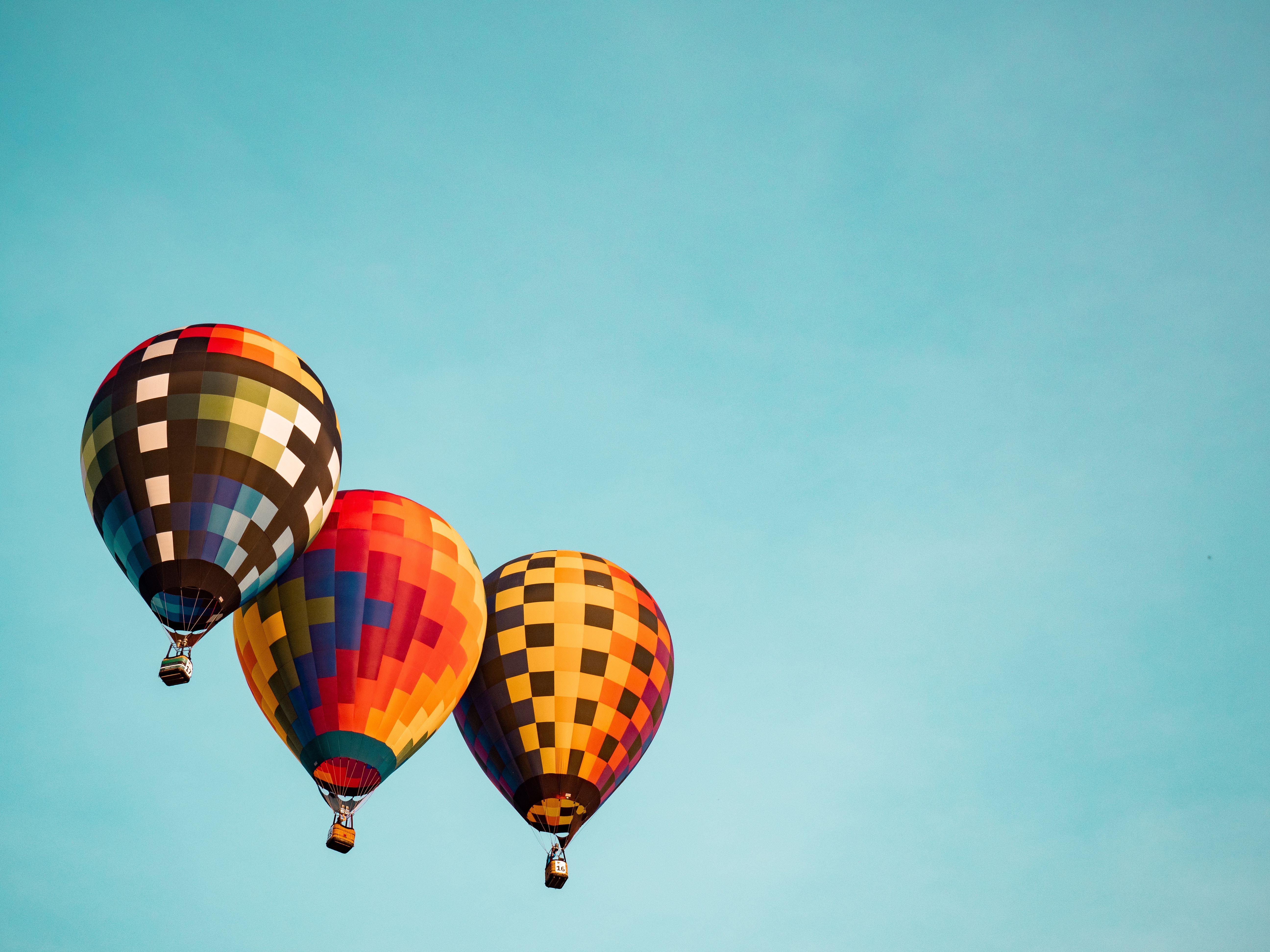 Three colorful hot air balloons in a blue sky HD Wallpaper
