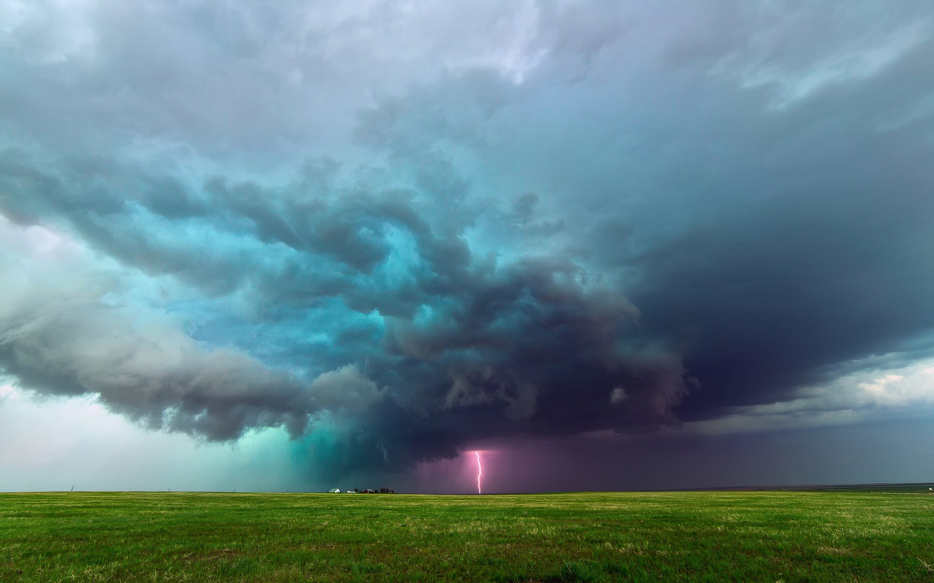 Lightning strike over a green field under storm clouds HD Wallpaper