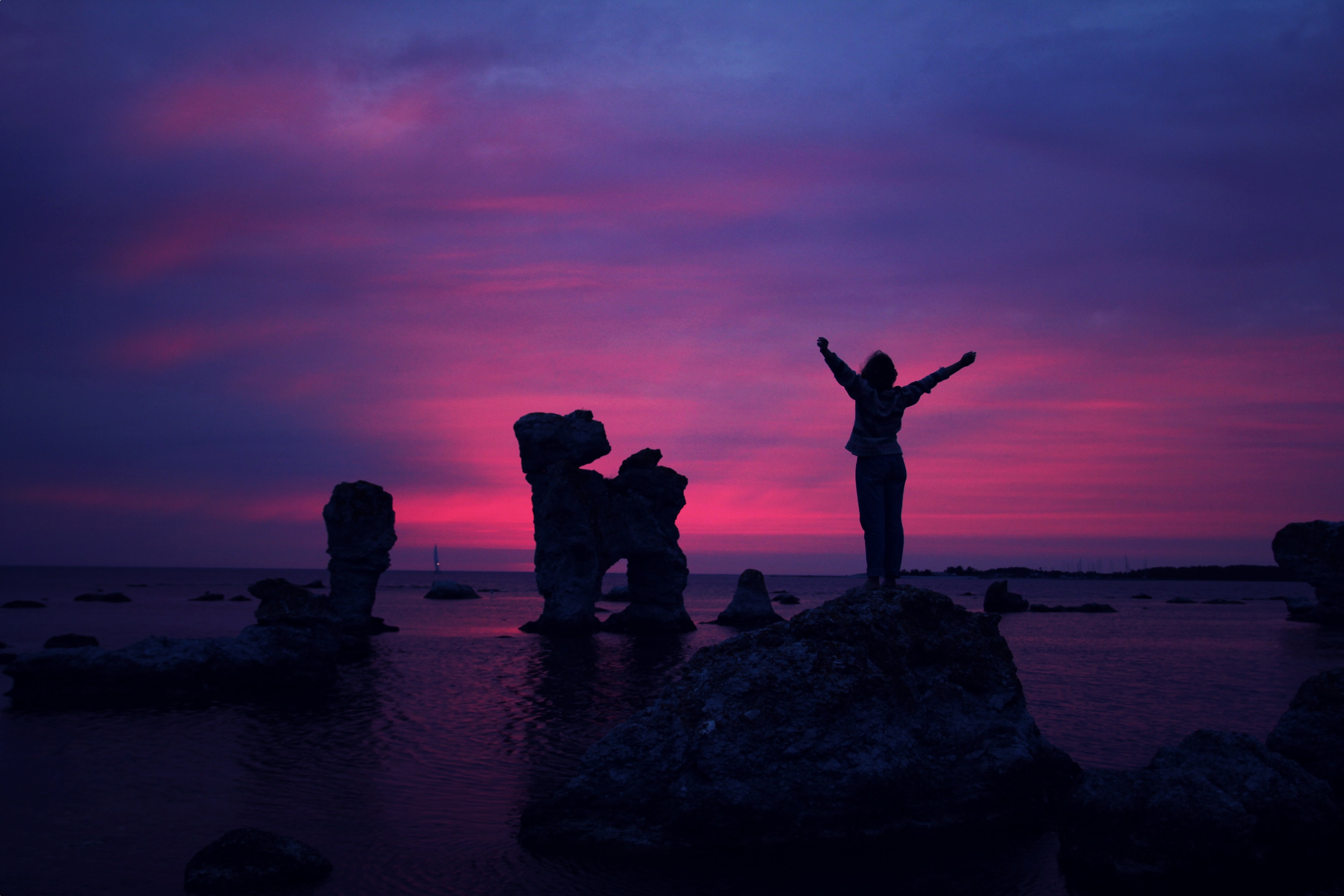 Woman silhouetted against a vibrant sunset over the sea HD Wallpaper