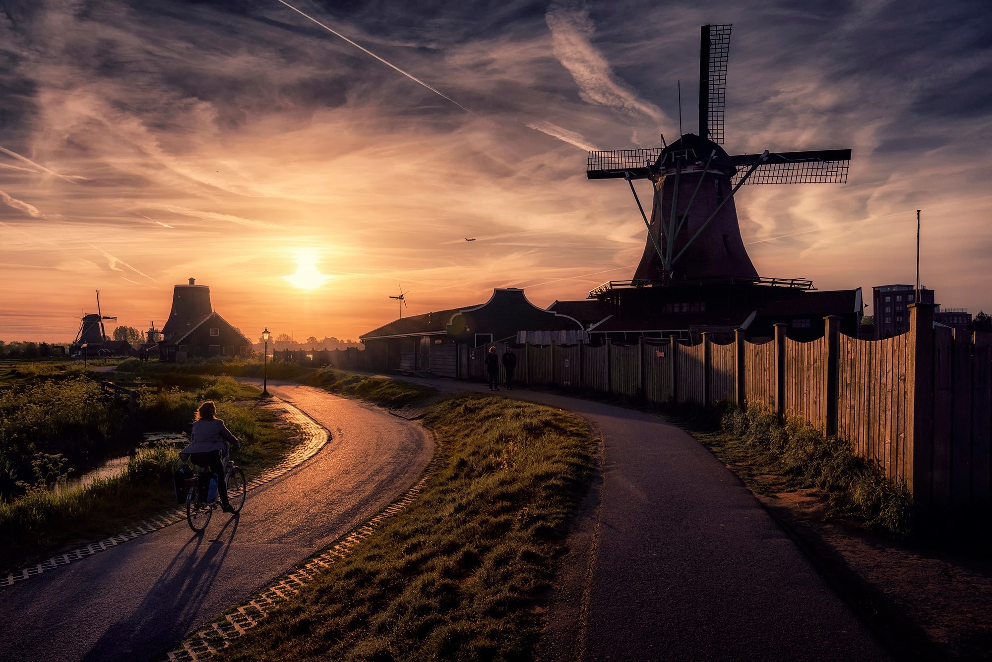 Sunset over windmills in the Netherlands with a cyclist HD Wallpaper