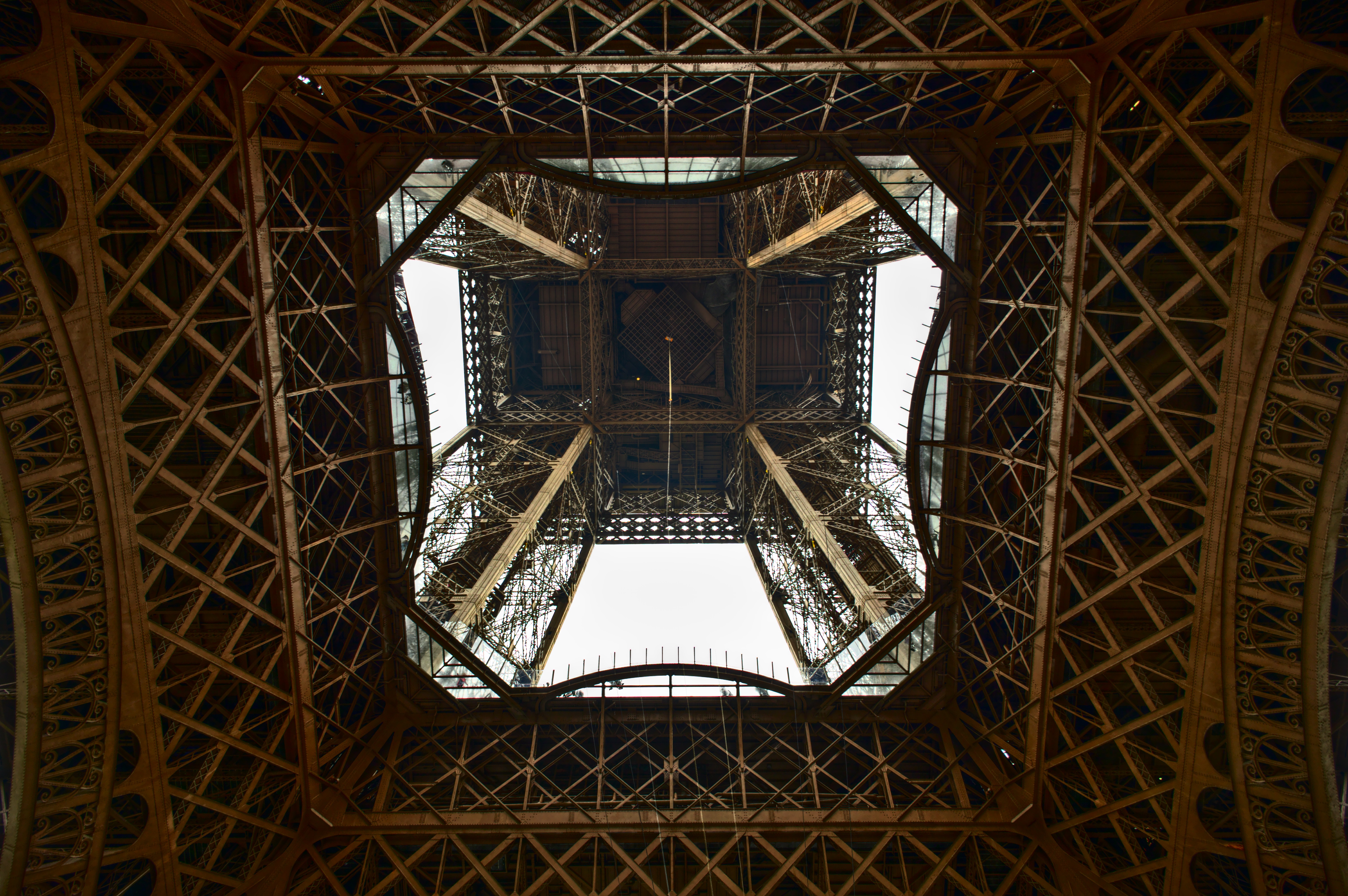 Looking up at the Eiffel Tower's iron framework in Paris HD Wallpaper