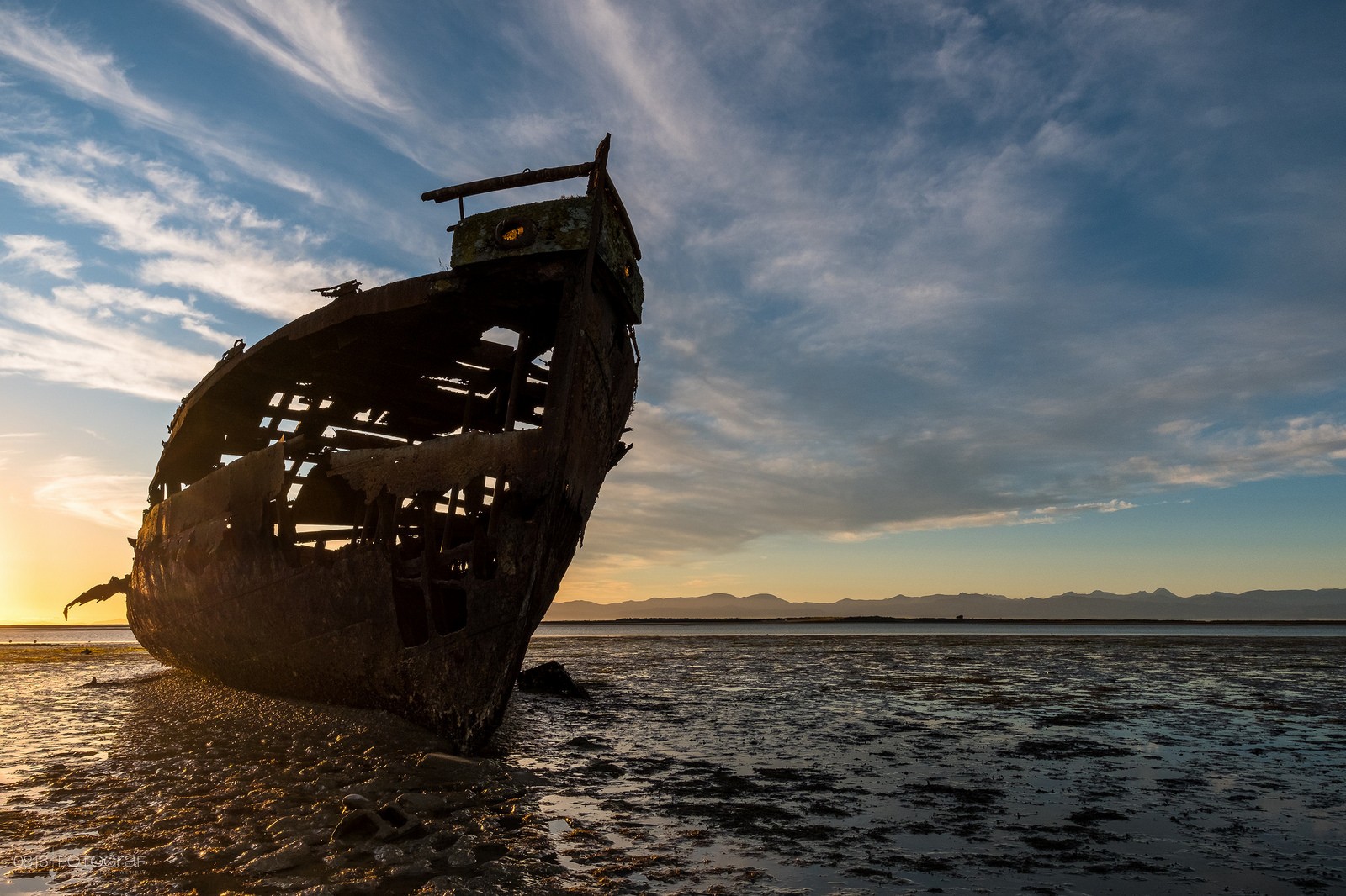 Abandoned shipwreck on a beach at sunset HD Wallpaper
