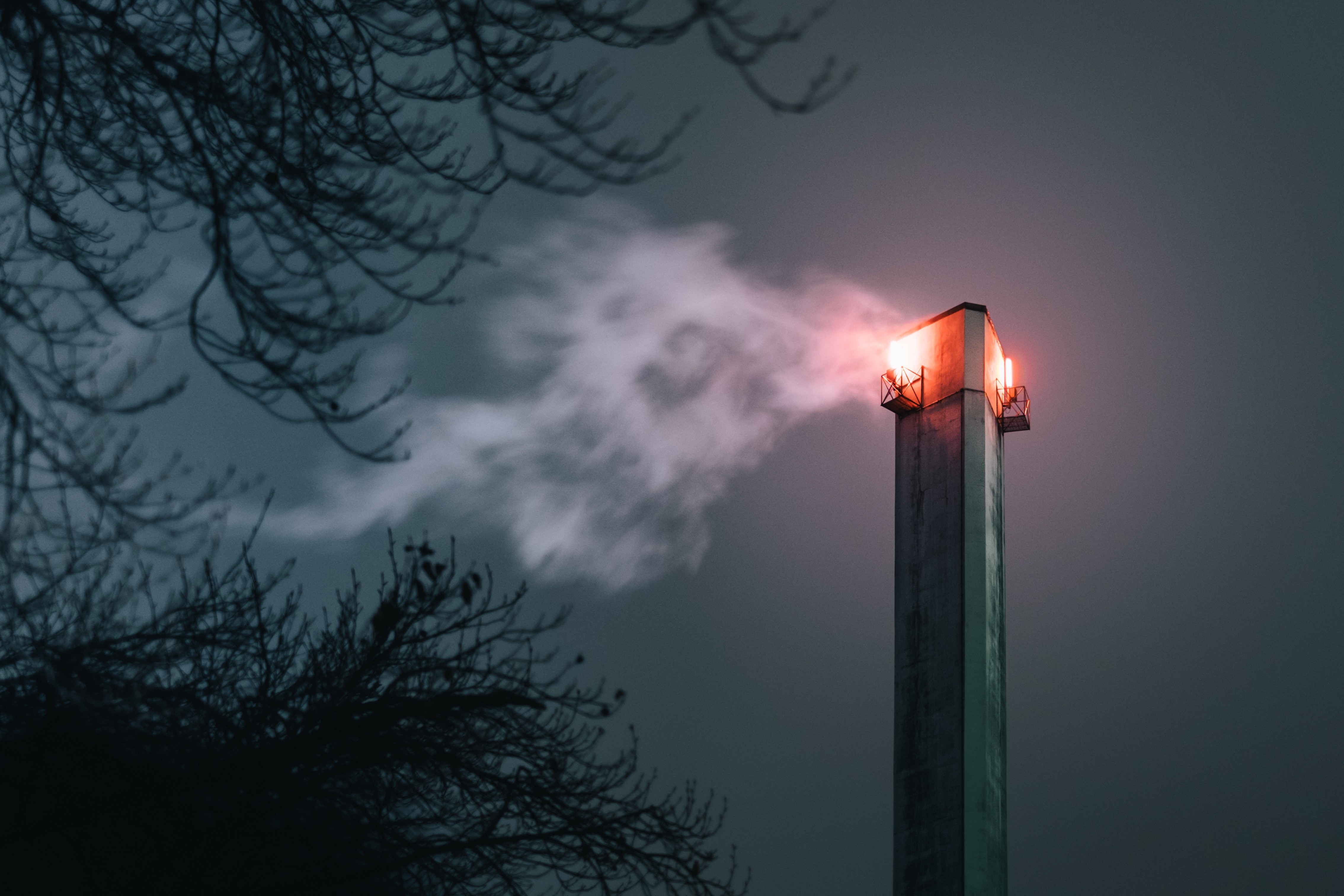 Chimney emitting smoke at night with trees HD Wallpaper