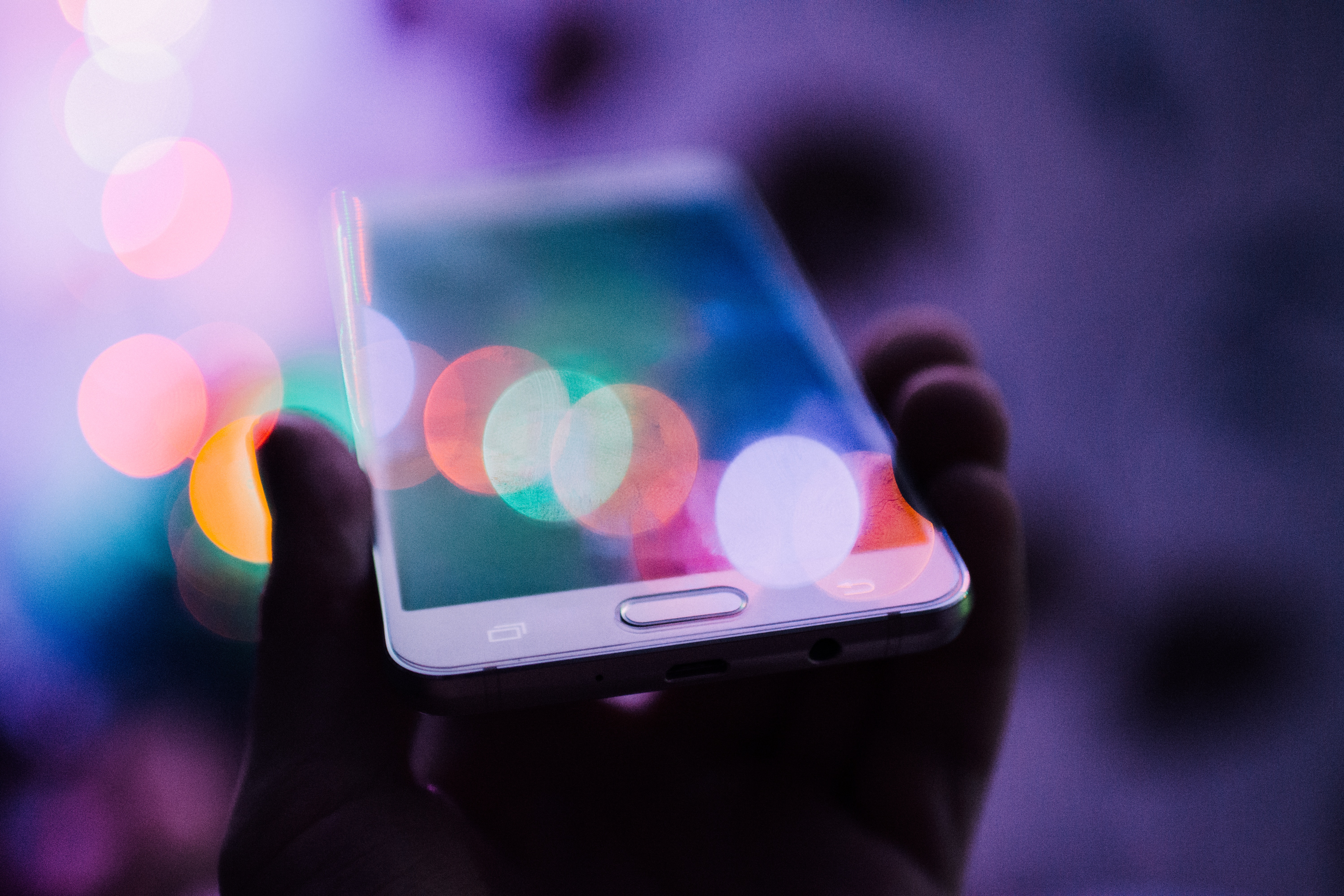 Samsung smartphone held in hand with bokeh lights HD Wallpaper