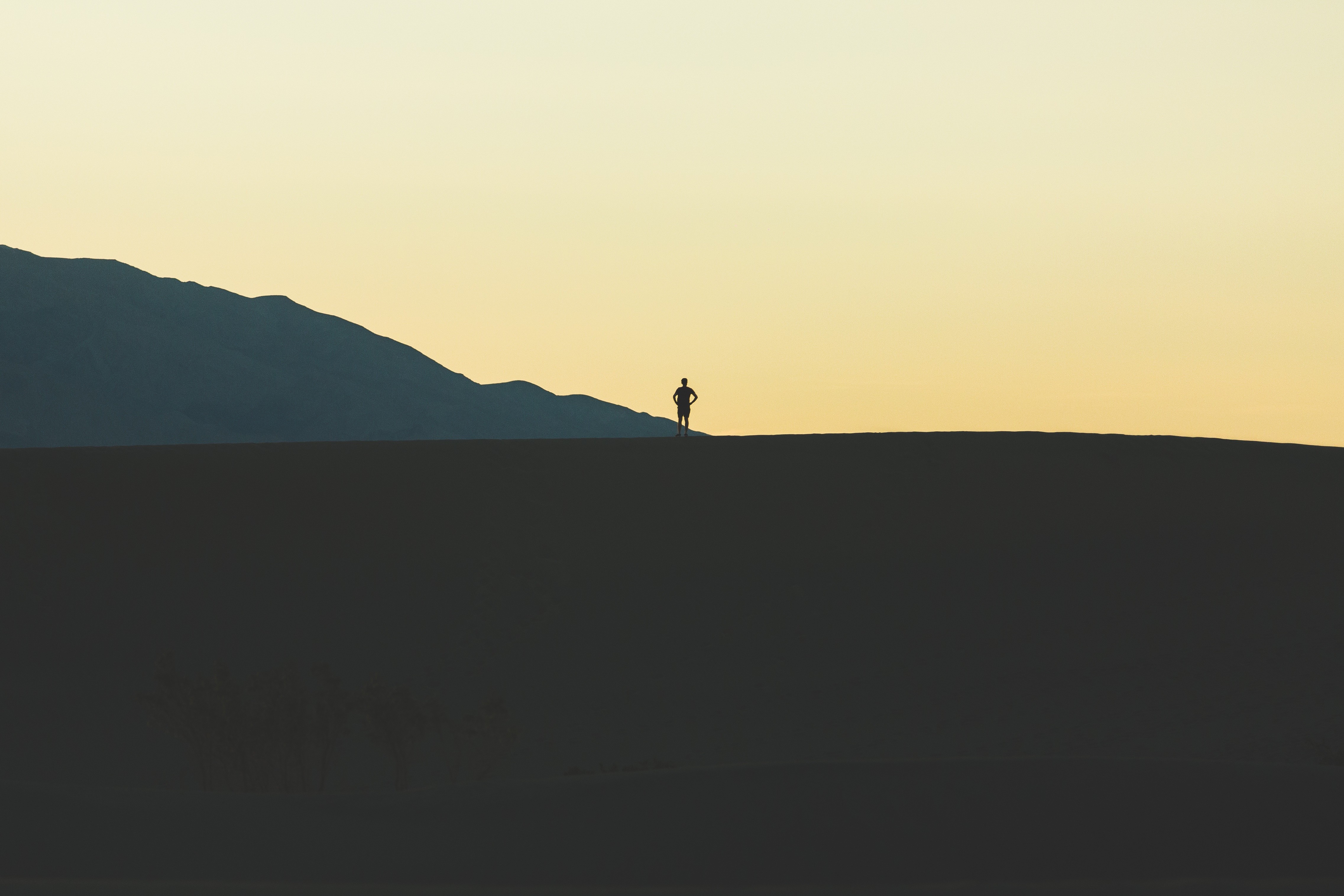 Silhouette of a person on a sand dune at sunset HD Wallpaper