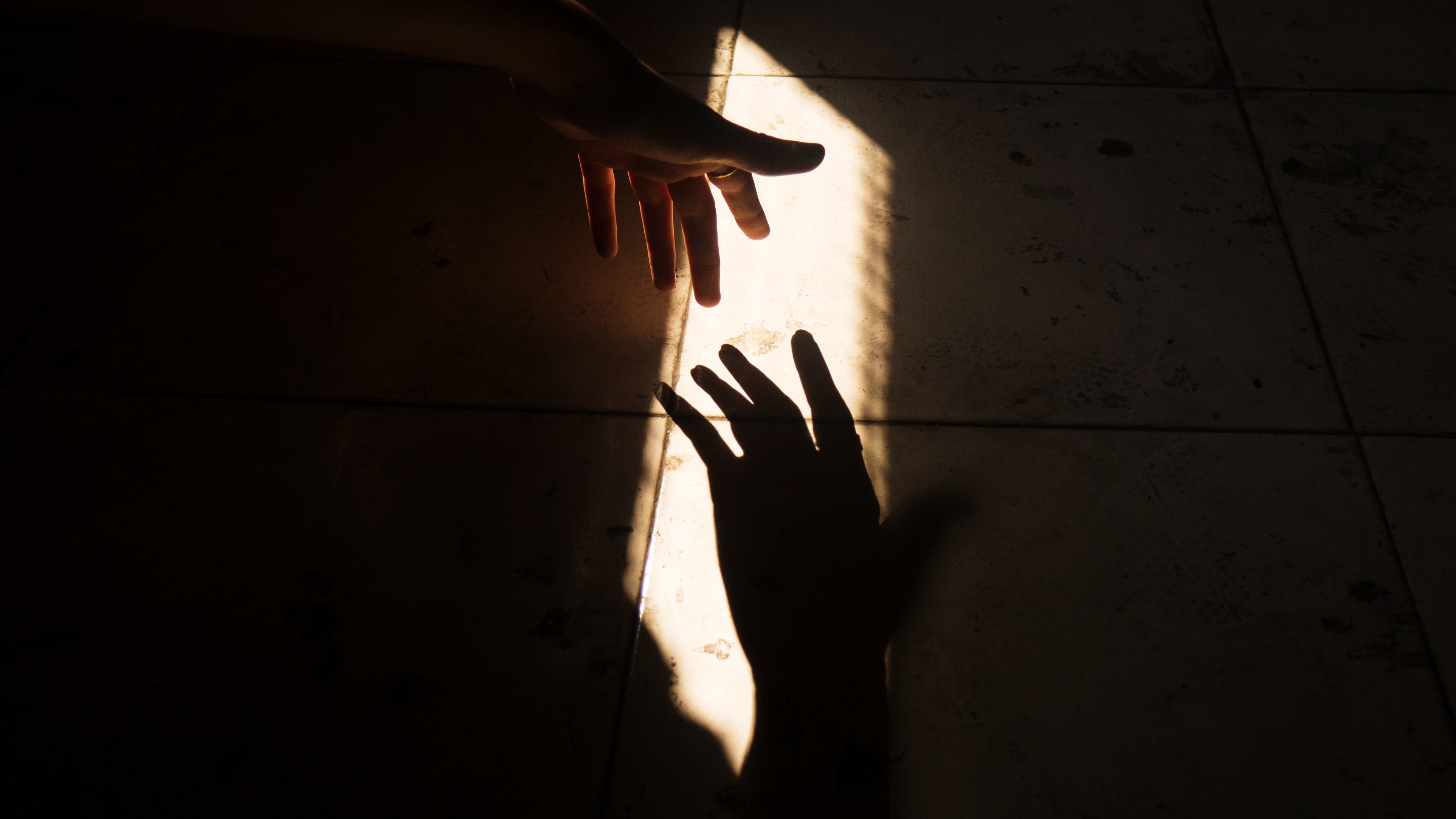 Two hands reaching for each other in sunlight HD Wallpaper