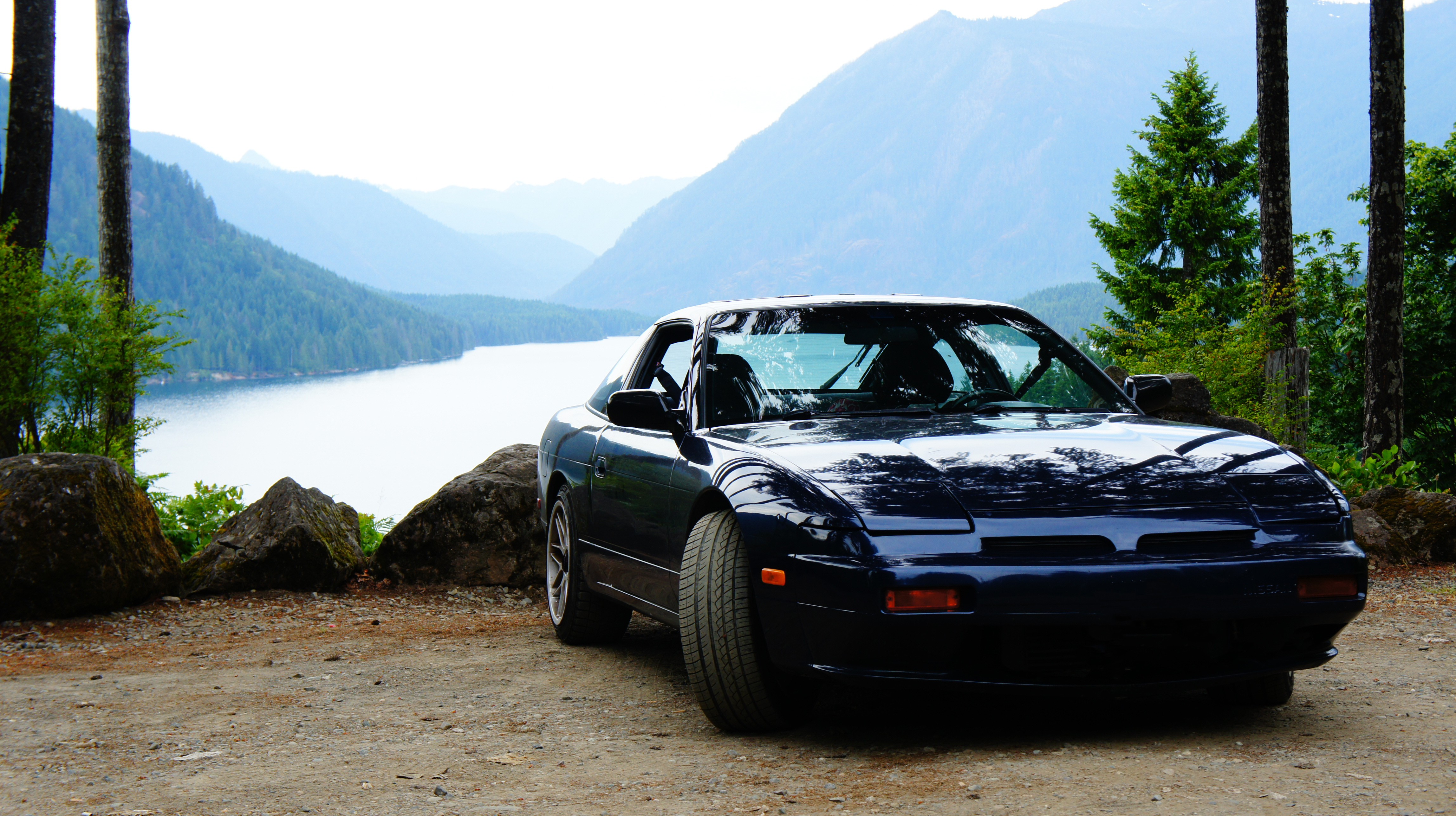 Nissan 240SX S13 parked by a lake with mountains HD Wallpaper
