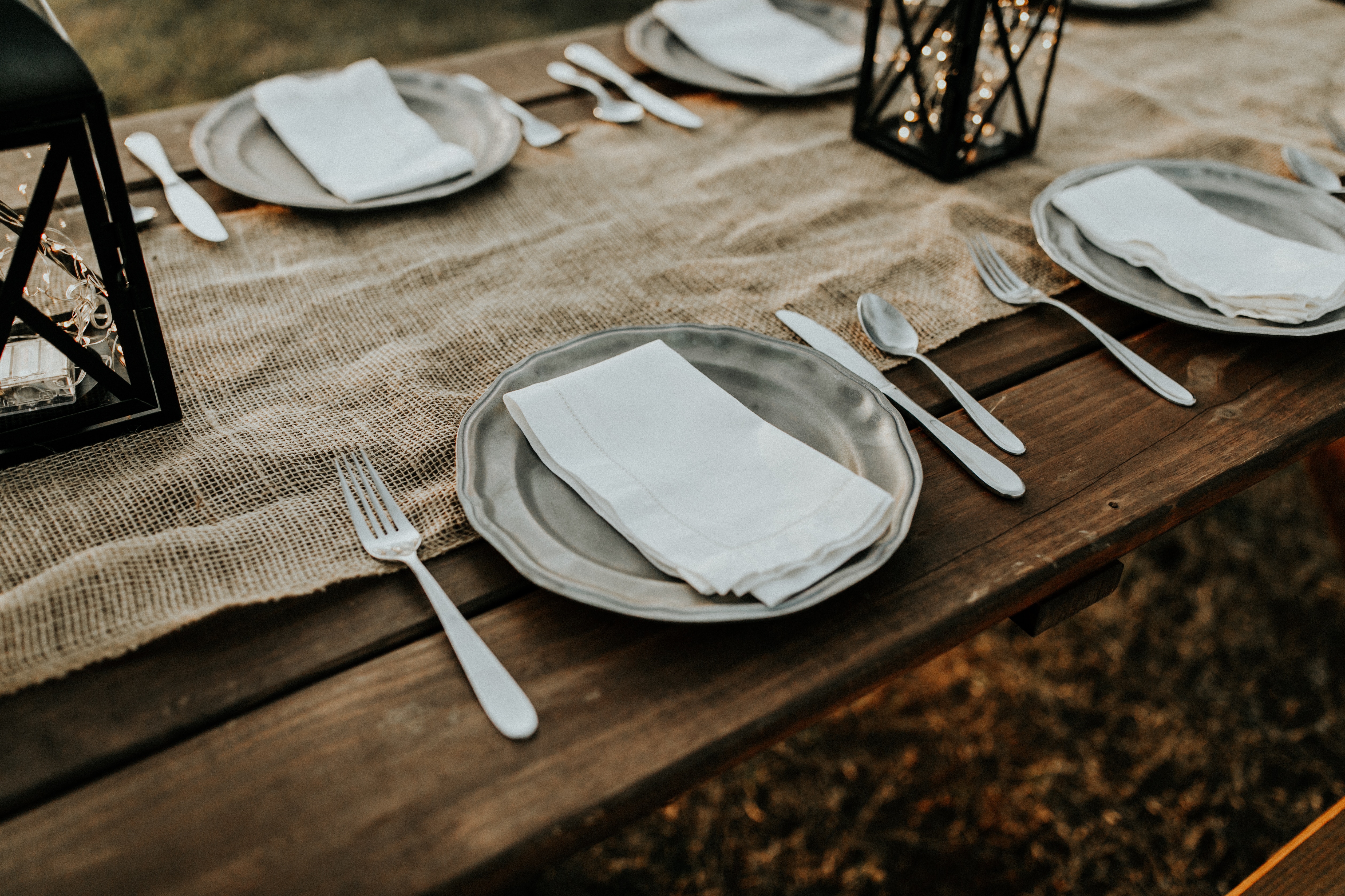 Table setting with plates, silverware, and lanterns HD Wallpaper