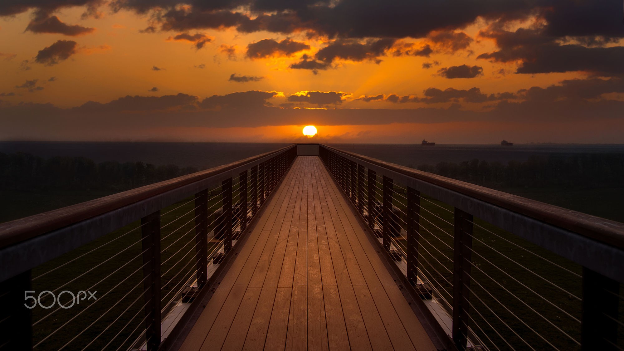 Wooden walkway towards sunset over the ocean HD Wallpaper