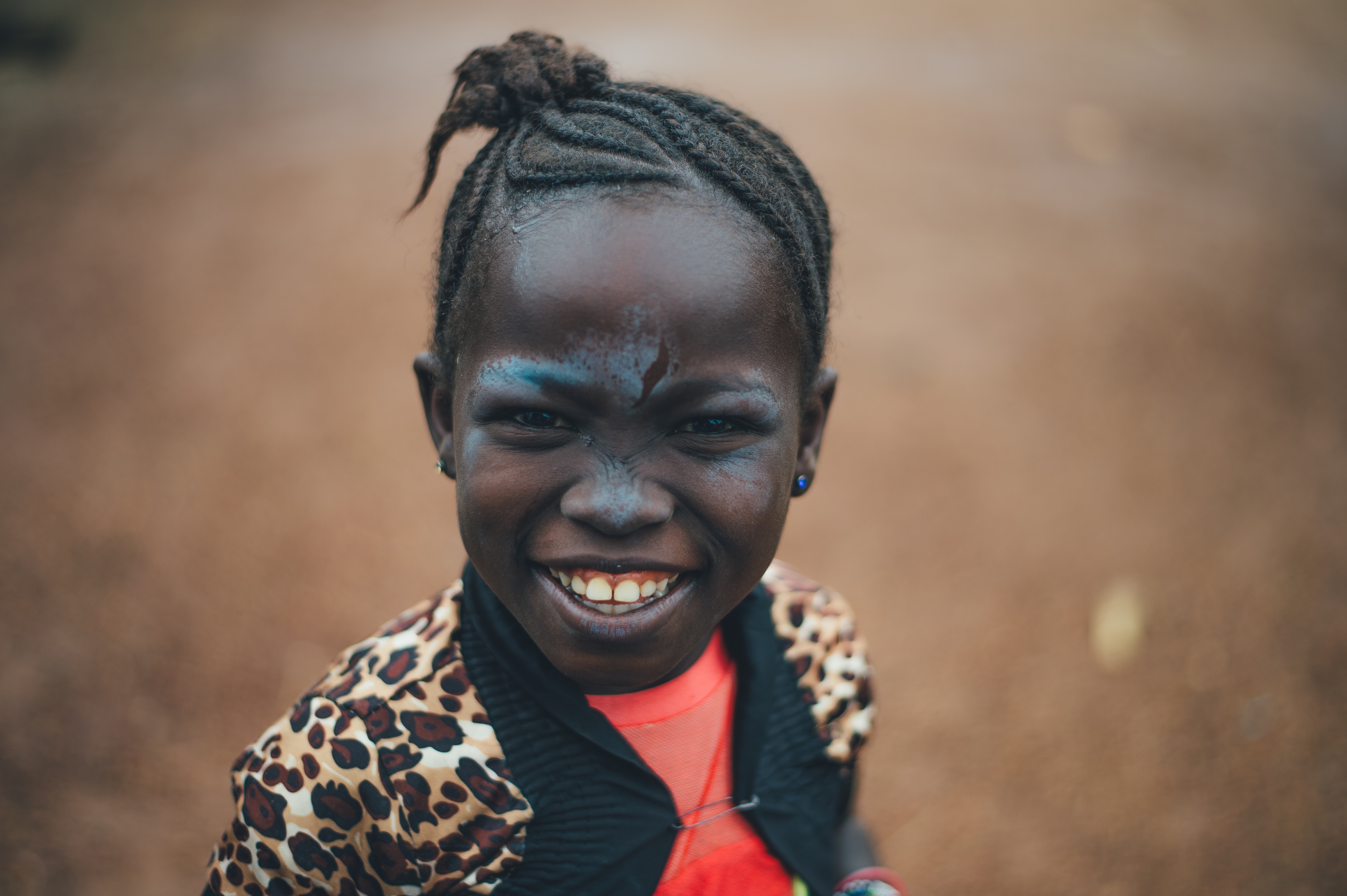African girl with braids and face paint smiles HD Wallpaper