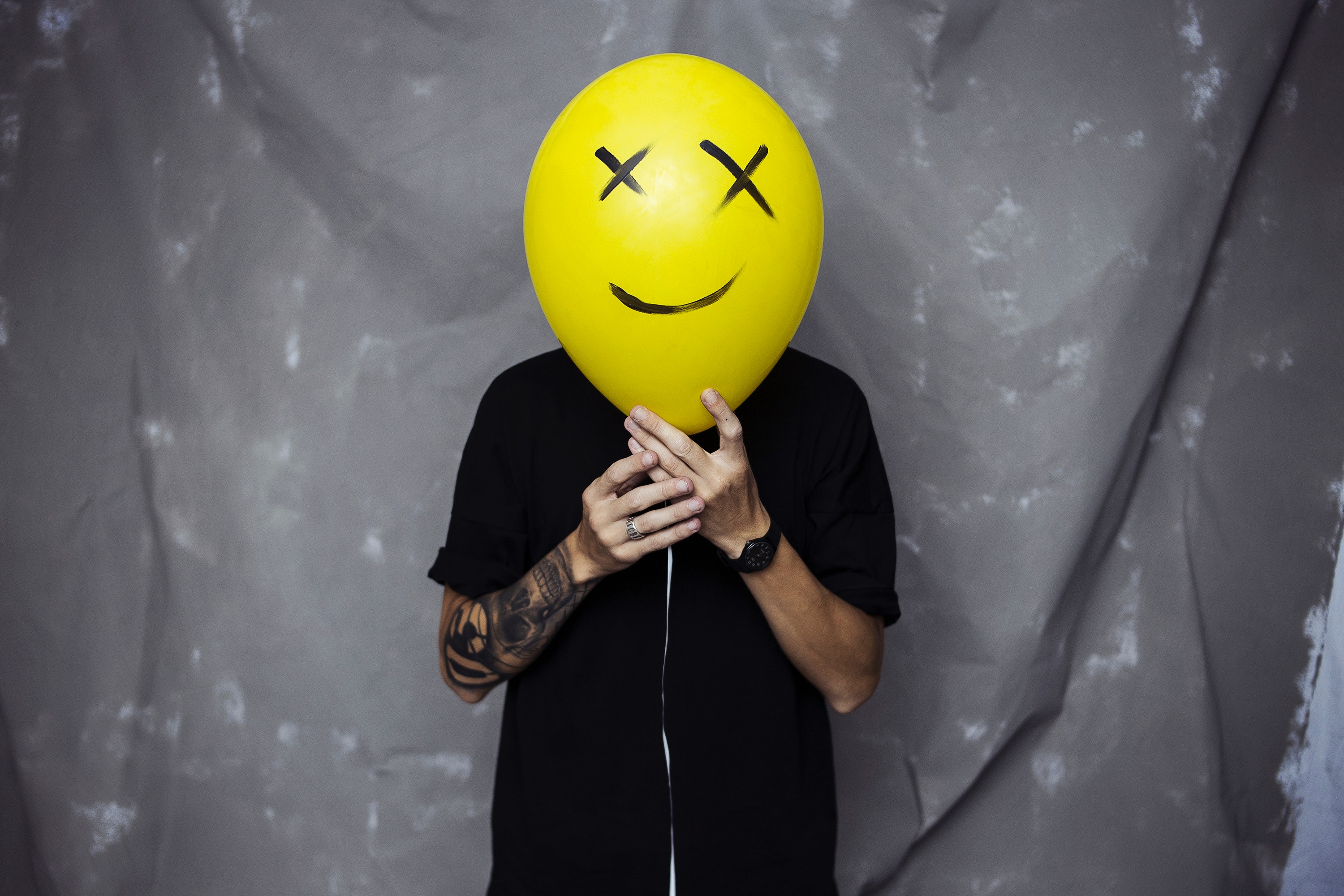 Person with a yellow smiley face balloon over head HD Wallpaper