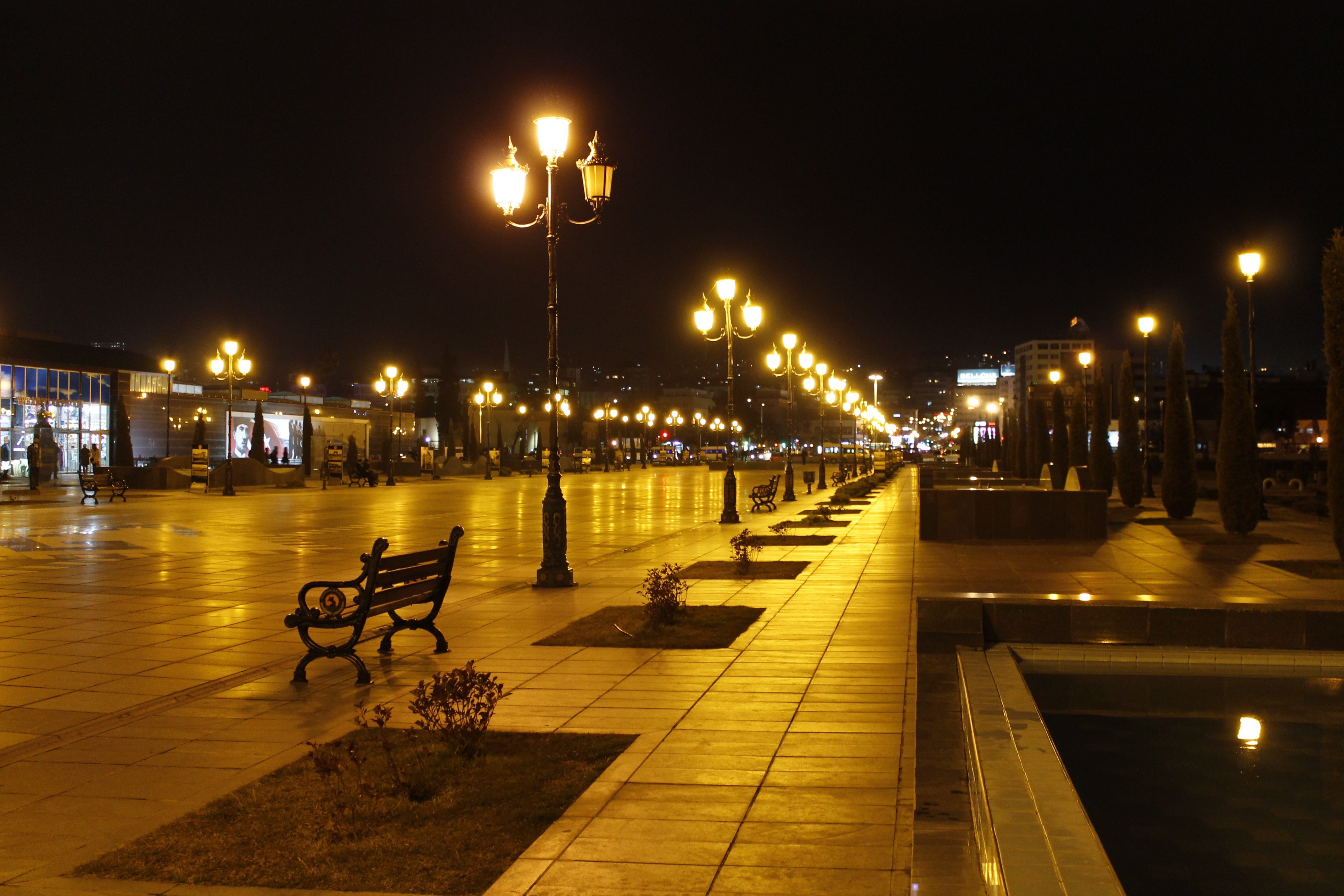 Cityscape at night with streetlights and benches HD Wallpaper