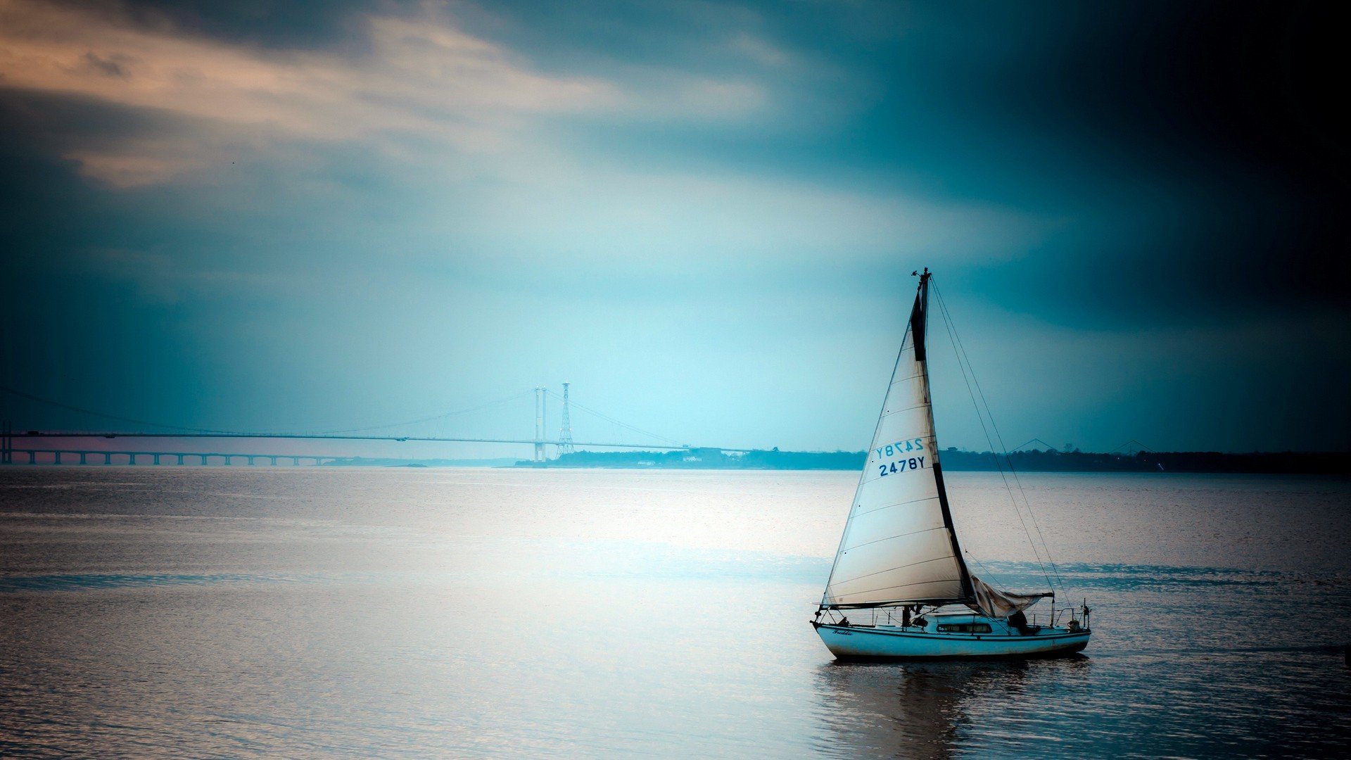 Sailboat on the water with a bridge in the background HD Wallpaper